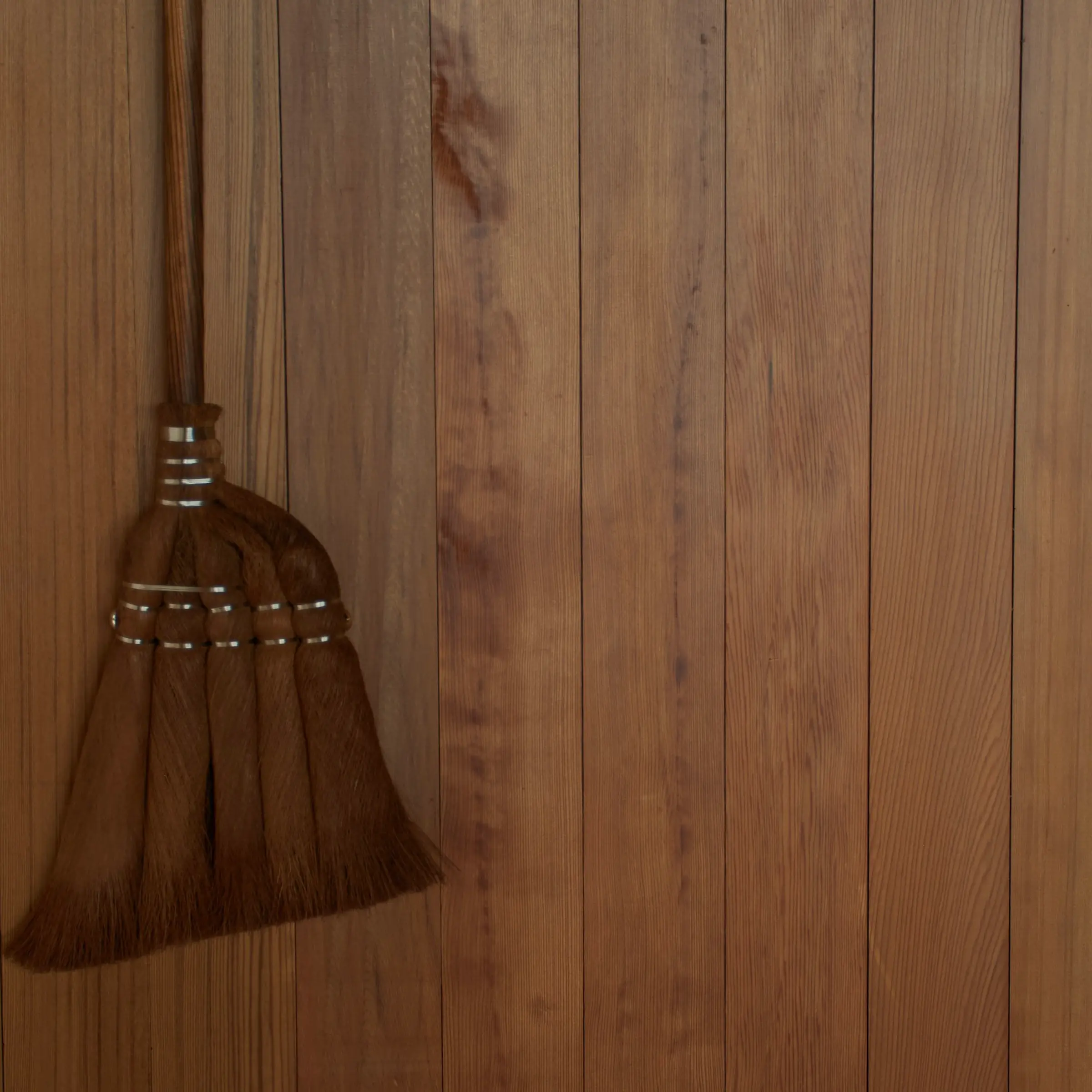 Brushes, brooms, body brushes hung up on a white wall