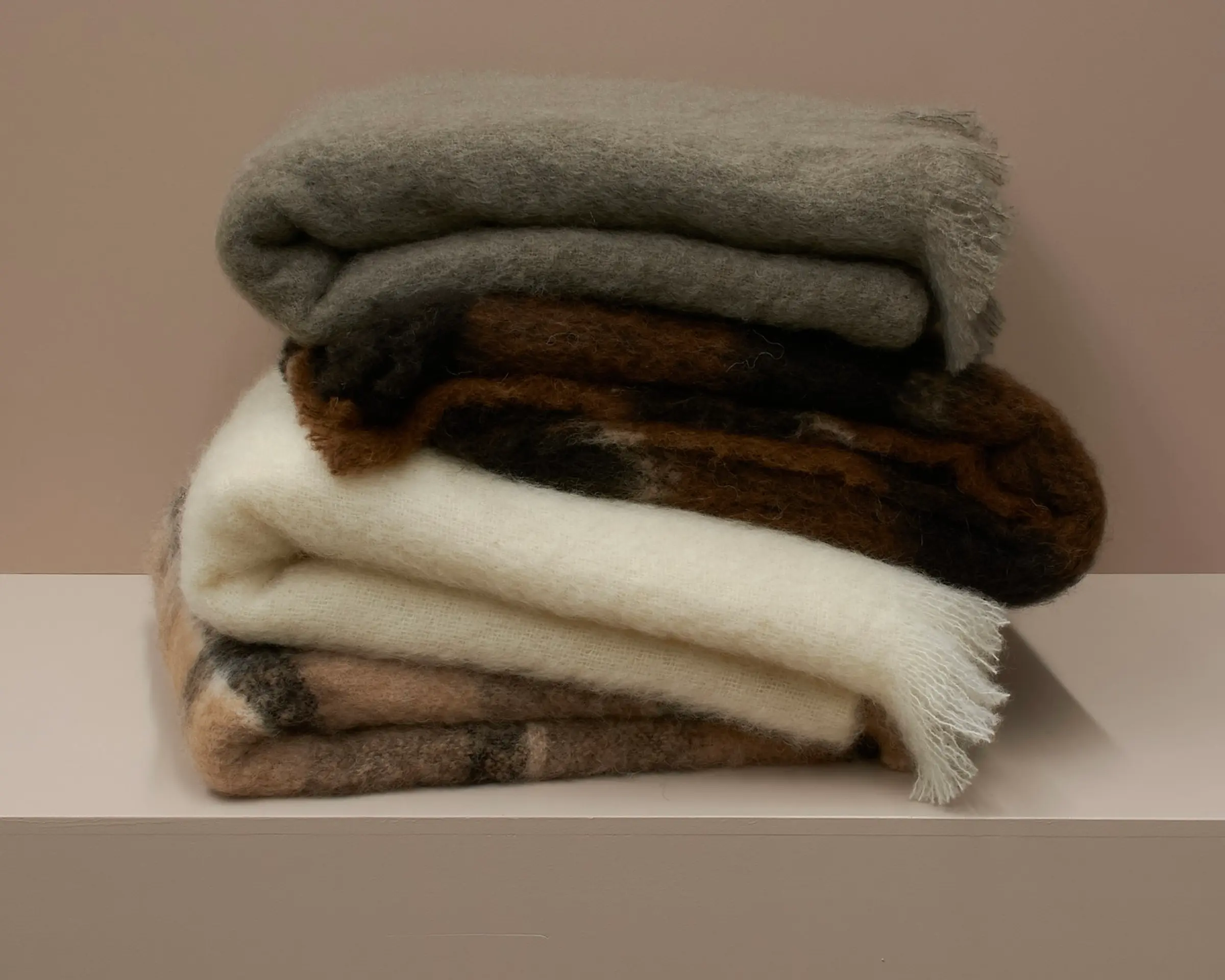 a stack of mohair blankets on a plinth