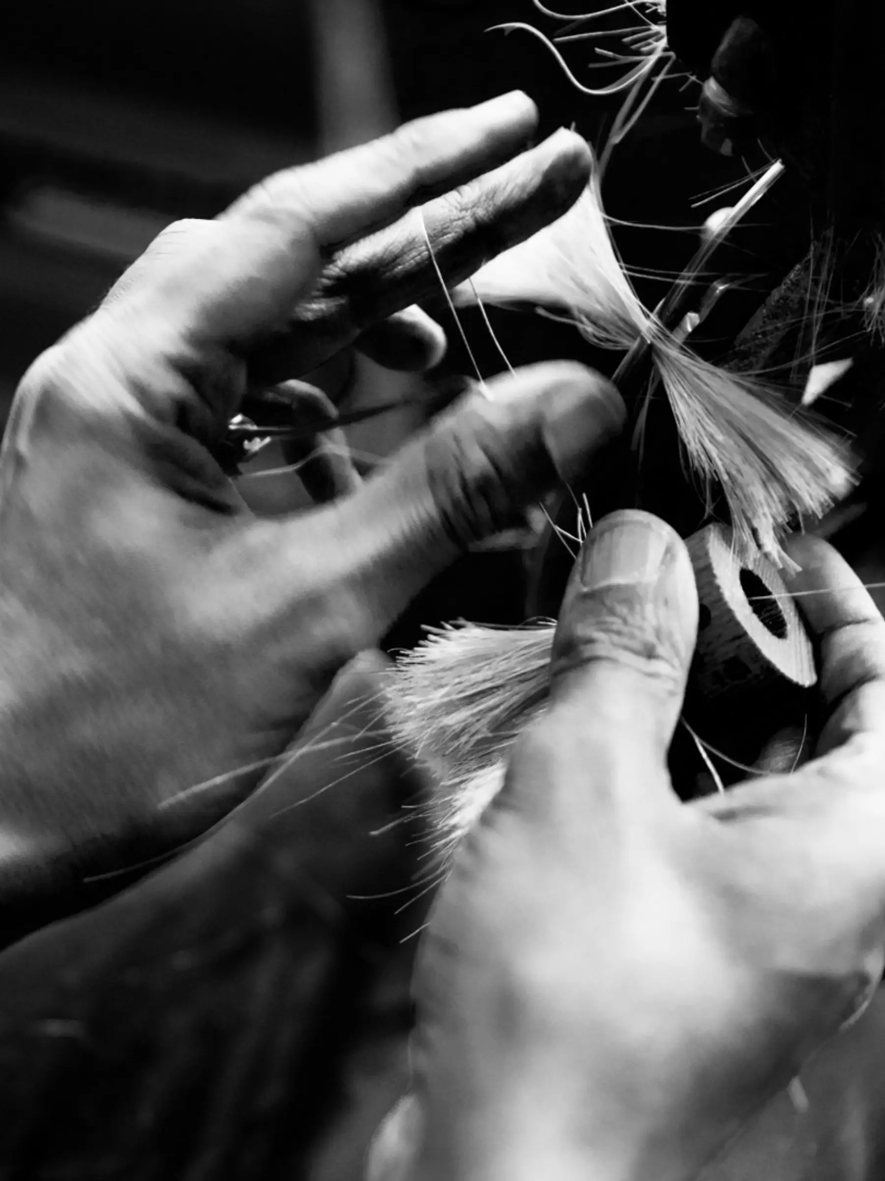 a brush maker looping threads while binding brushes