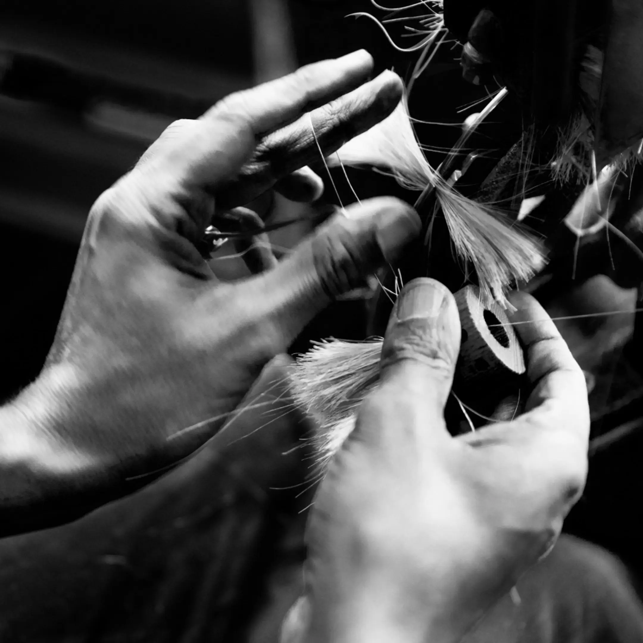 a brush maker looping threads while binding brushes