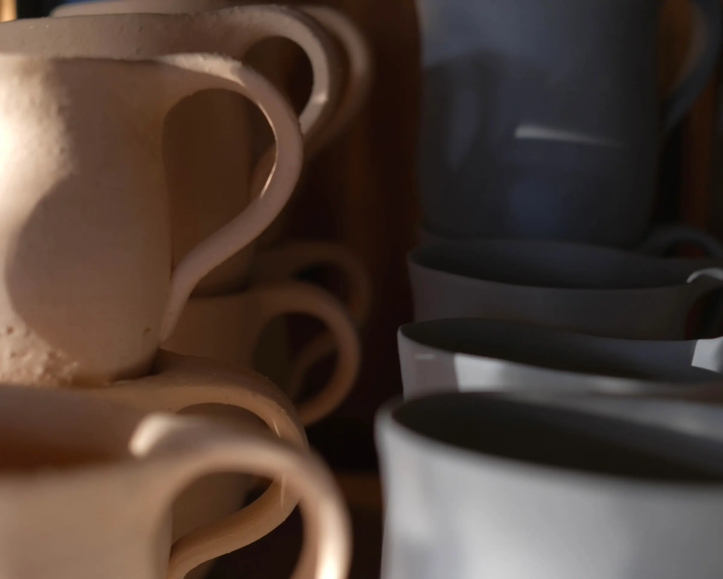 Handmade stoneware mugs and cups by New Zealand ceramic artist Kaiqi Qiu, photographed in natural light in her Grey Lynn studio.