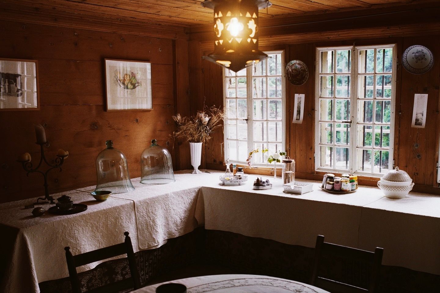 An image from scenery magazine no4, an l shaped dining table in an old hour with decorative objects adorned