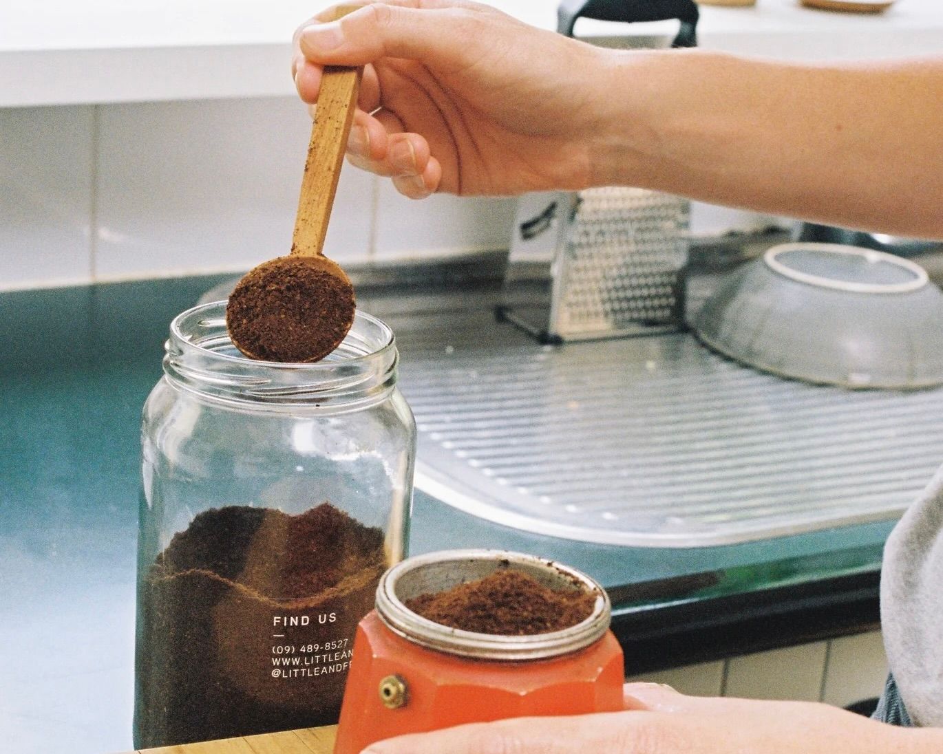 An insitu shot of Courtney Petleys hand carved wooden Coffee scoops being used to scoop coffee grinds into the bottom of a coffee pot