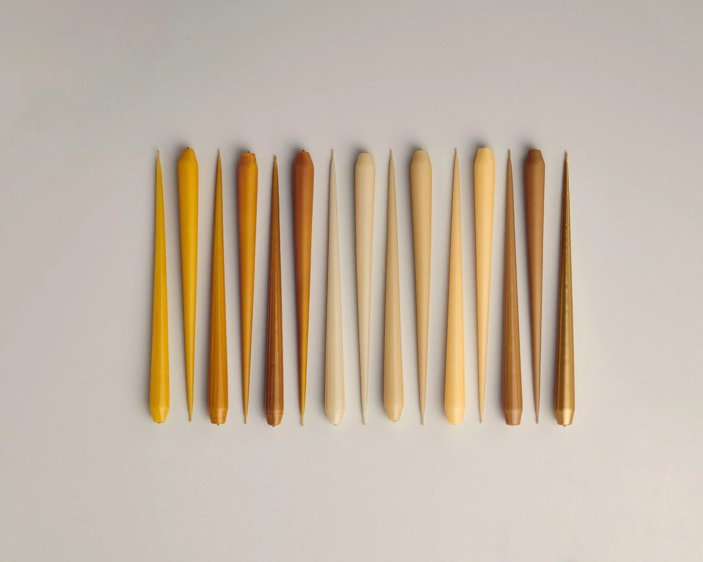 Eric taper candles 32cm amber toned hand dipped laid on a table