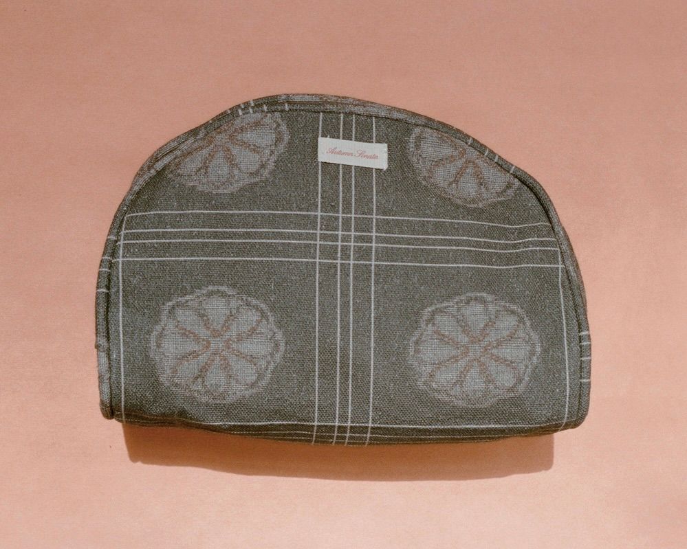 The Eva toiletry bag from Autumn Sonata on a. peach coloured background