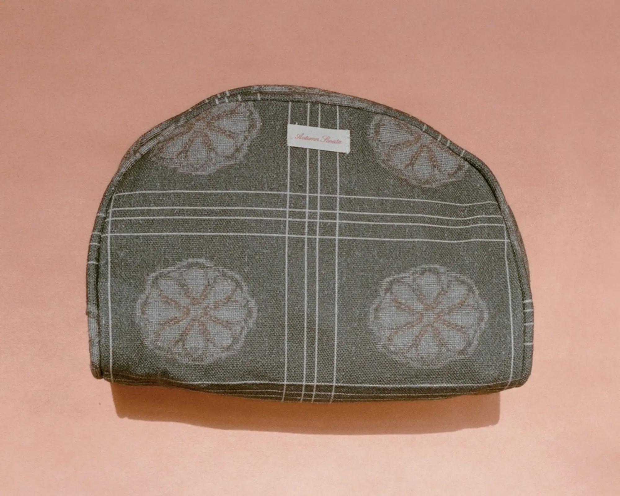The Eva toiletry bag from Autumn Sonata on a. peach coloured background