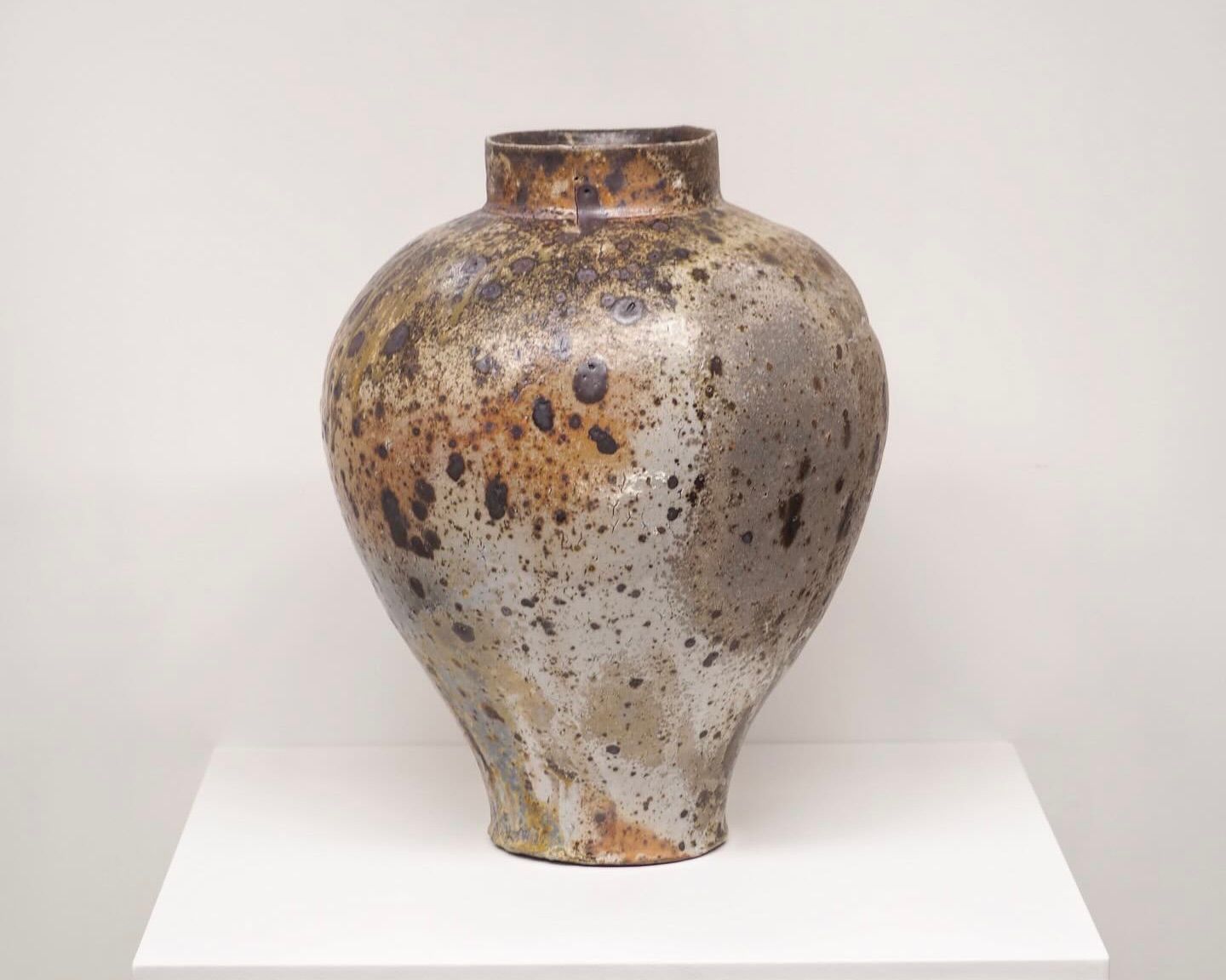 An anagama vase from Holly rose Morgan on a white plinth and background