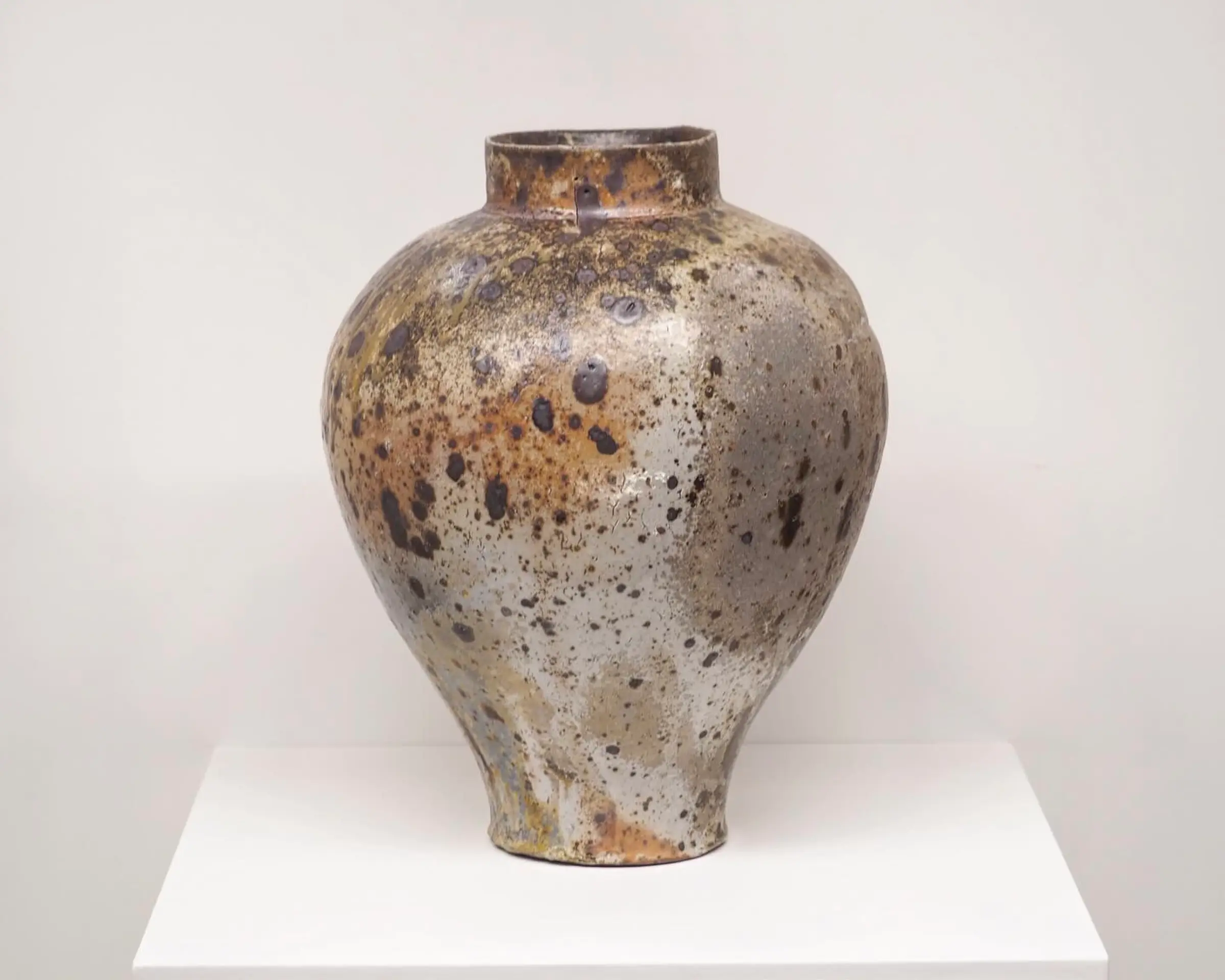 An anagama vase from Holly rose Morgan on a white plinth and background