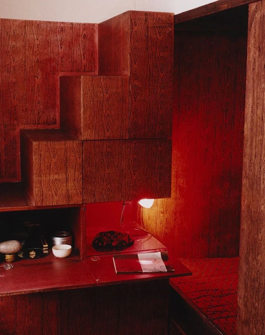 An image from inside of Scenery Magazine, from London. A room filled with wooden veneer walls and a red glowing light in the corner