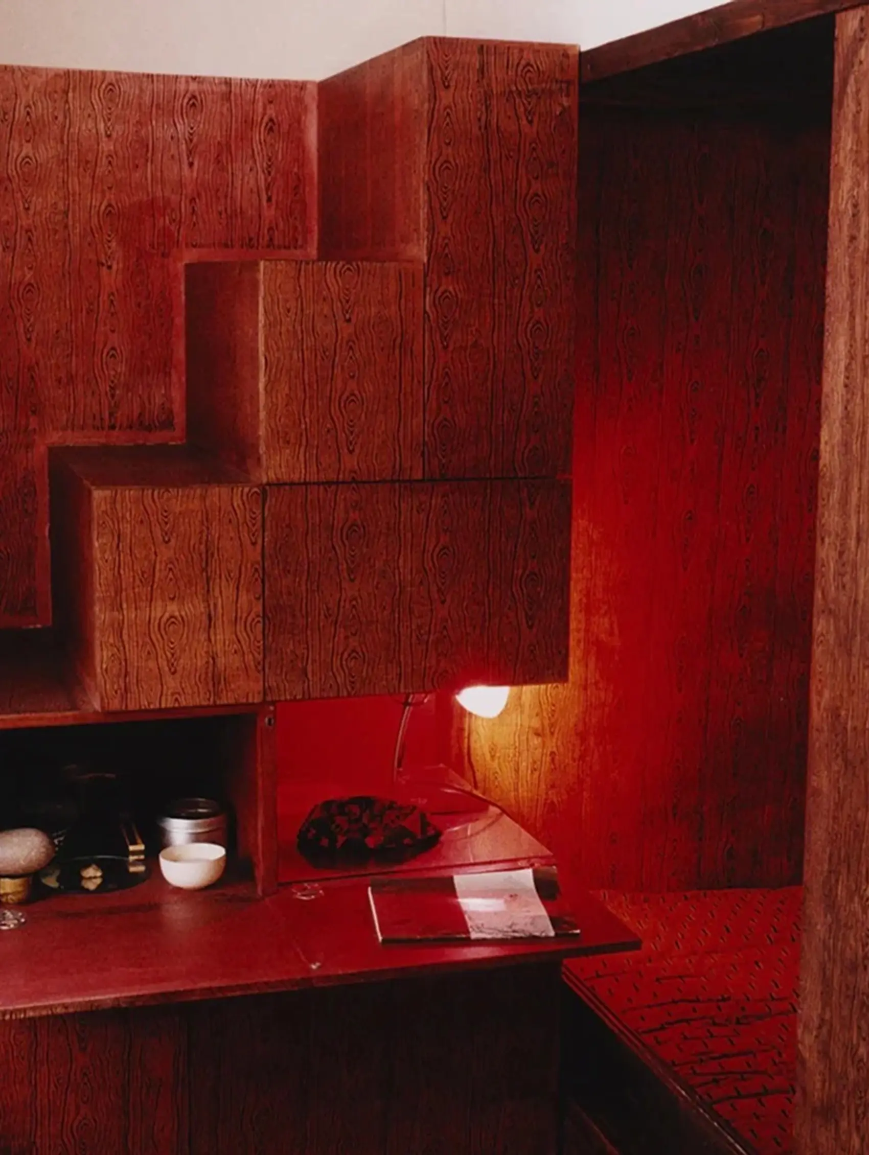 An image from inside of Scenery Magazine, from London. A room filled with wooden veneer walls and a red glowing light in the corner