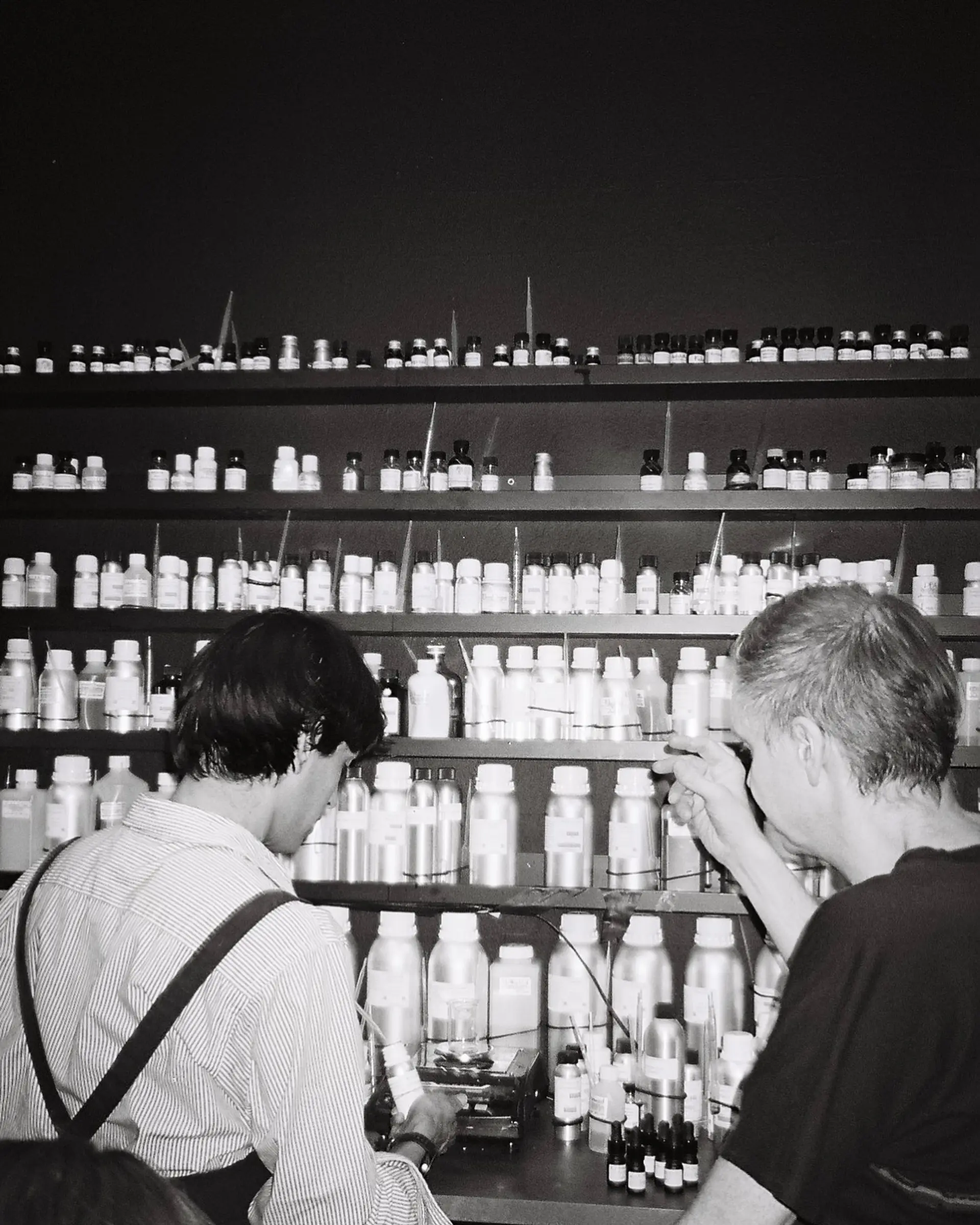 Two men testing fragrance samples to blend into a perfume