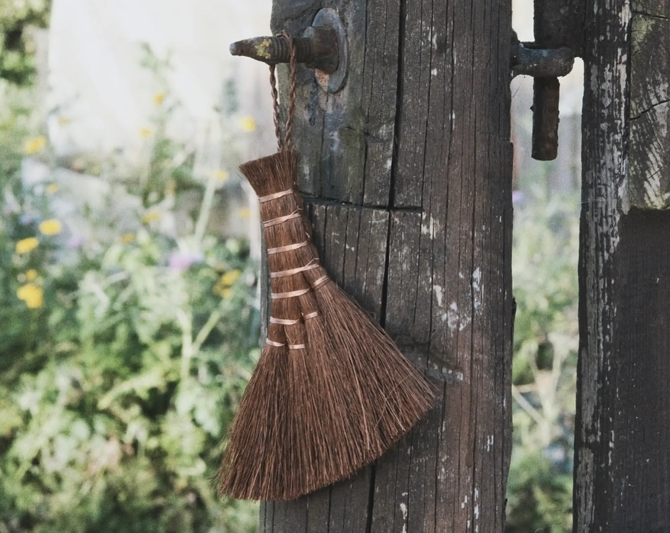 A shuro brush hanging on a fence post