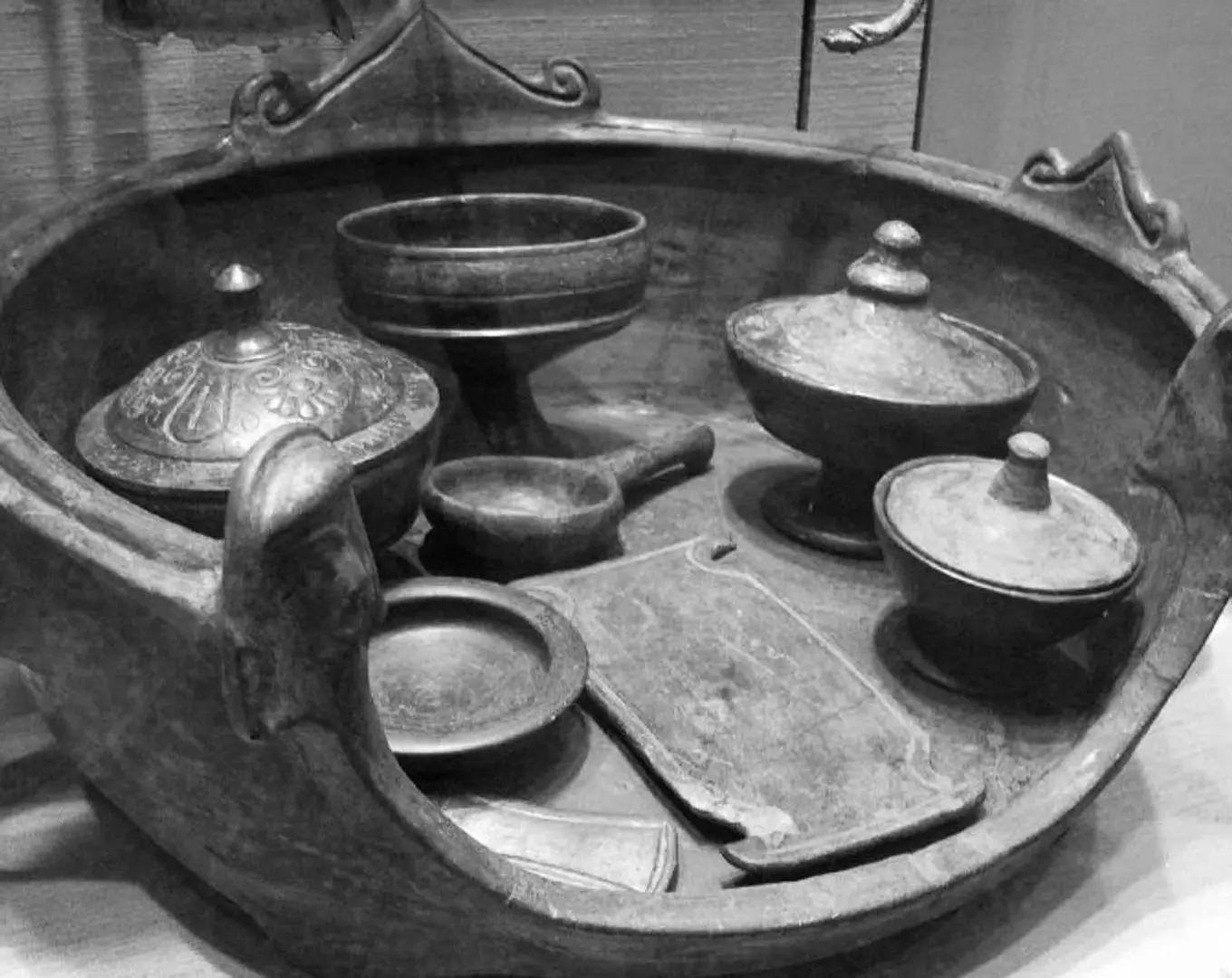 a collection of Etruscan era pottery in a glass cabinet of a museum