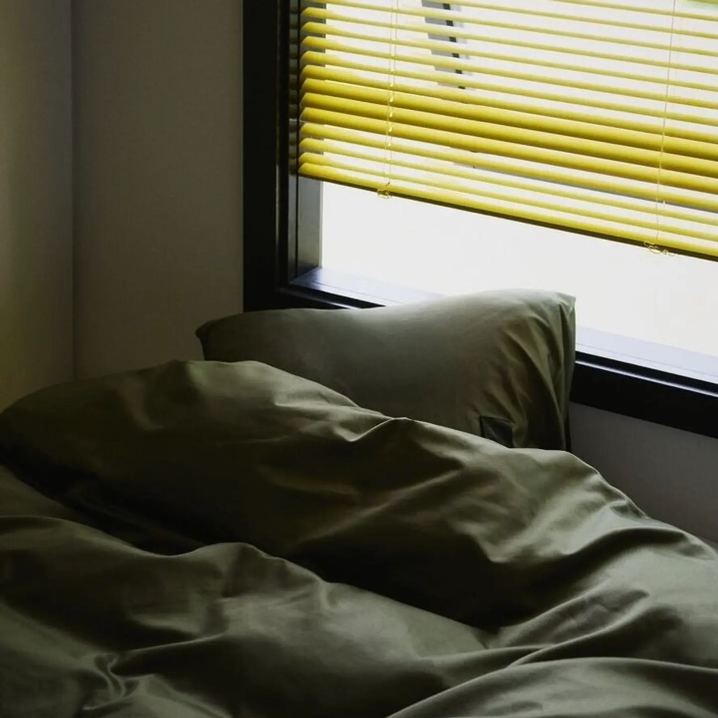 Magniberg bed linens on a bed with yellow blinds in the background