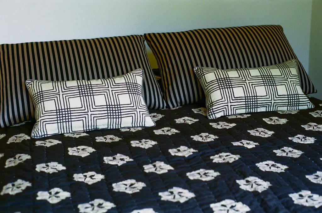 the studio ford leaflet quilt on a bed in situ