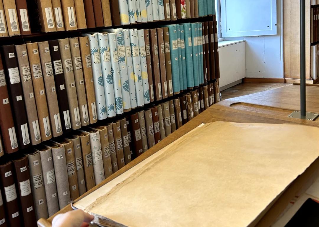 archival books in a bookshelf filled with antique jacquard samples and prints