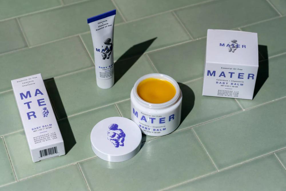 mater baby balm jar and tube on a tiled surface