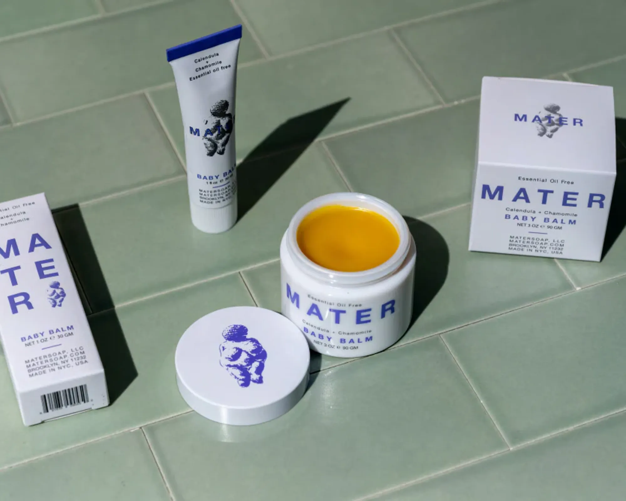 mater baby balm jar and tube on a tiled surface