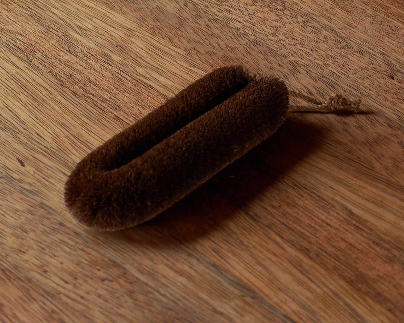 tawashi slim scrub brush on a wooden bench top