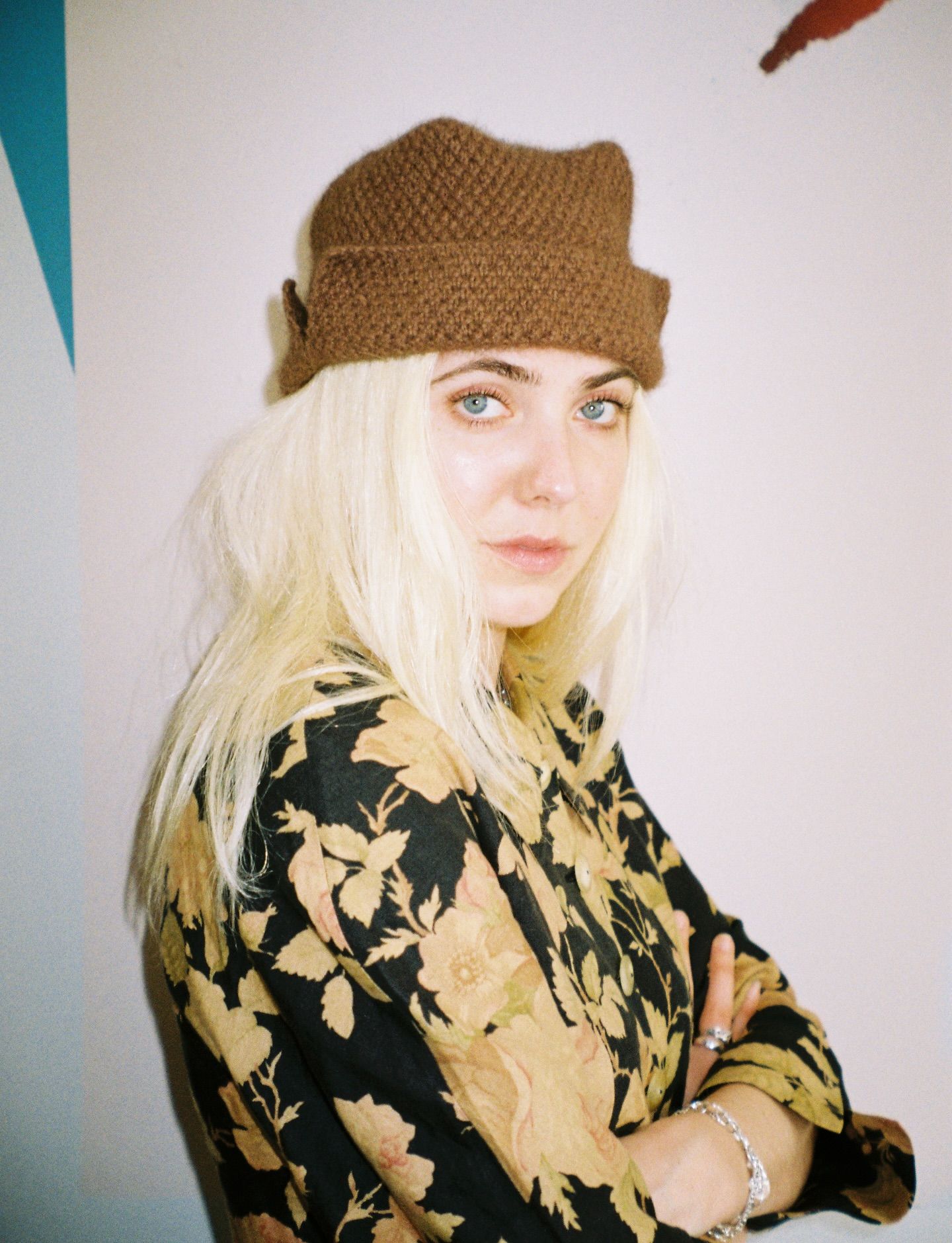 A woman wearing a Bonnie Wroe hand knit Ted hat made from a possum merino blend yarn, a square flat top shape. Well designed knitwear accessories made by hand