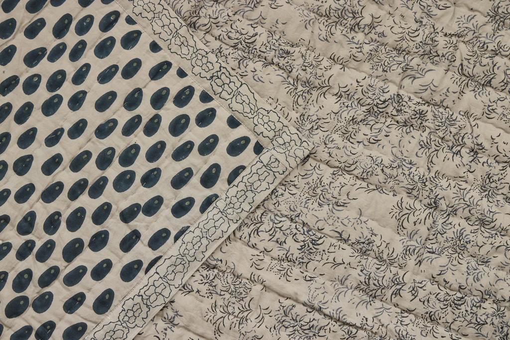 a close up of the two sides of the Studio ford oracle quilt in soft grey and deep blue