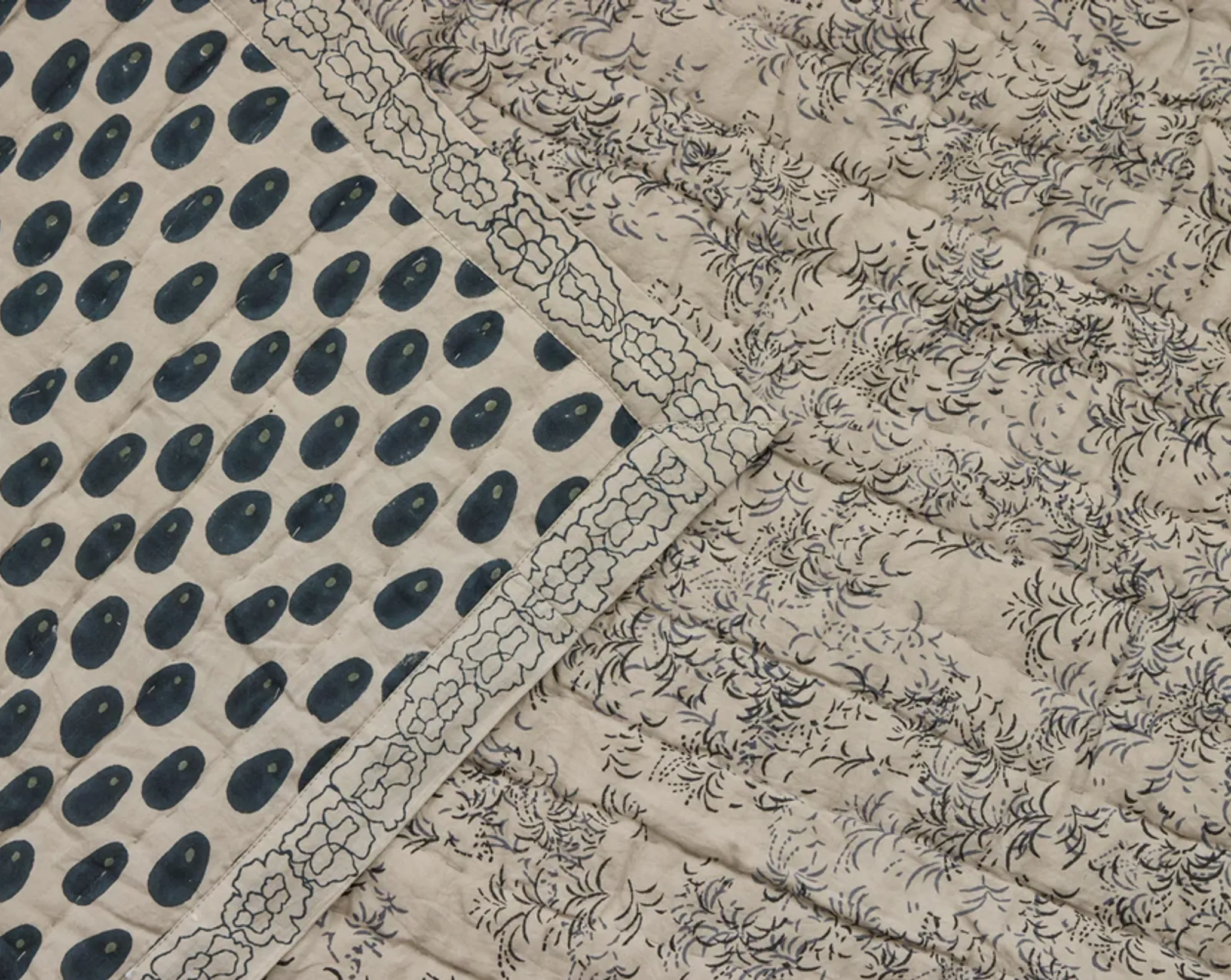 a close up of the two sides of the Studio ford oracle quilt in soft grey and deep blue