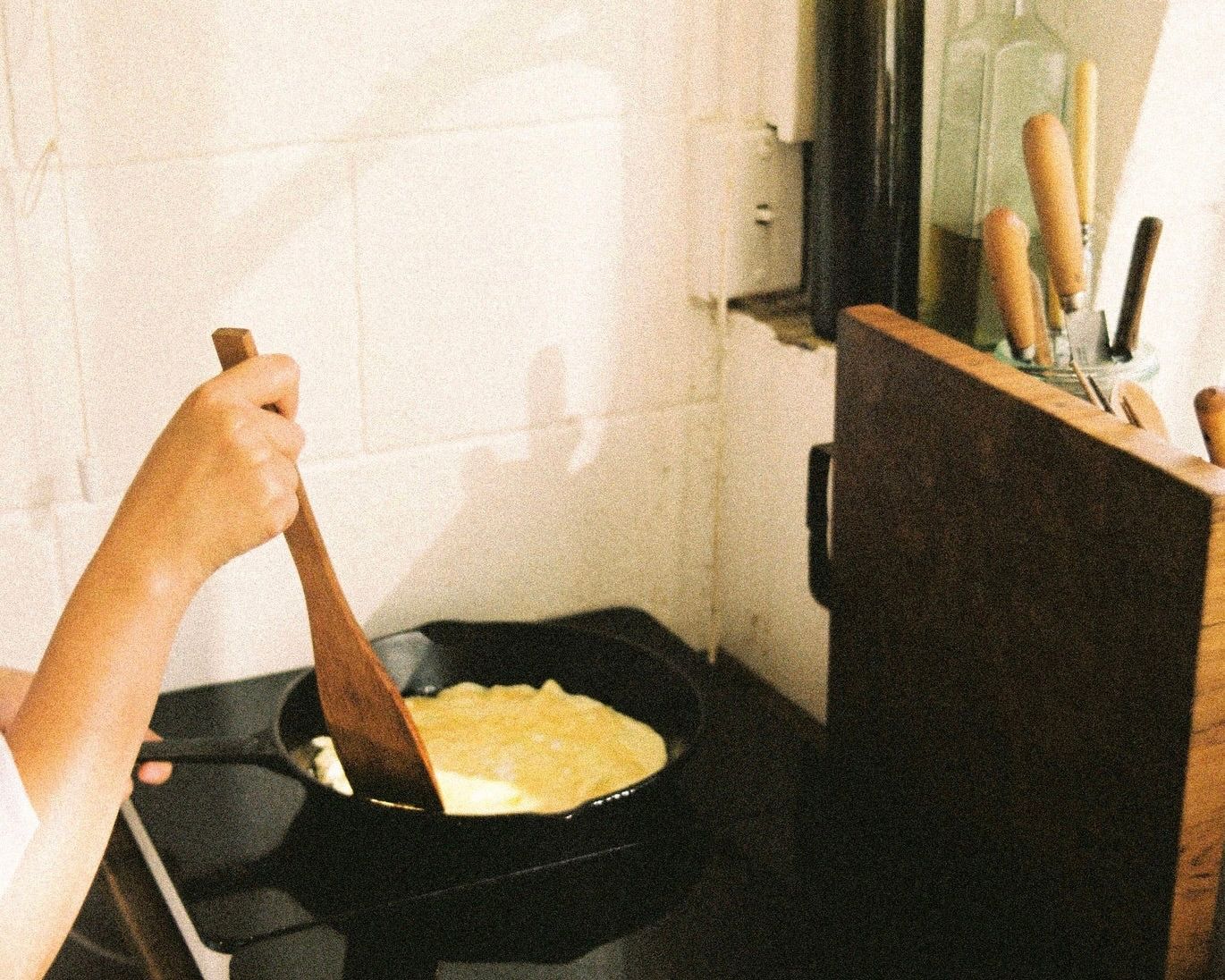 an insitu shot in a kitchen cooking eggs with Courtney Petleys Square flip spatula hand made from Matai in New Zealand