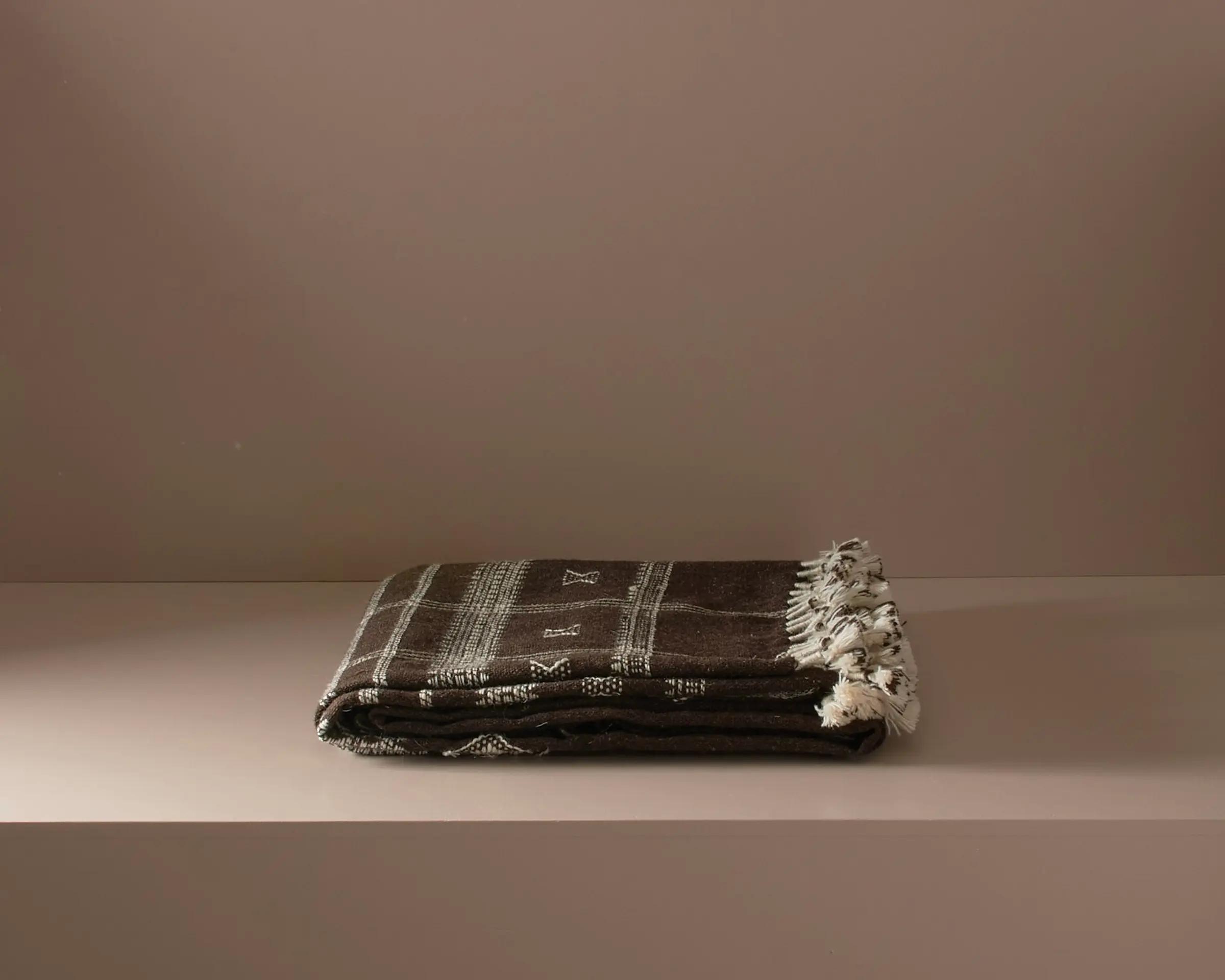 handwoven woollen throw on a neutral background