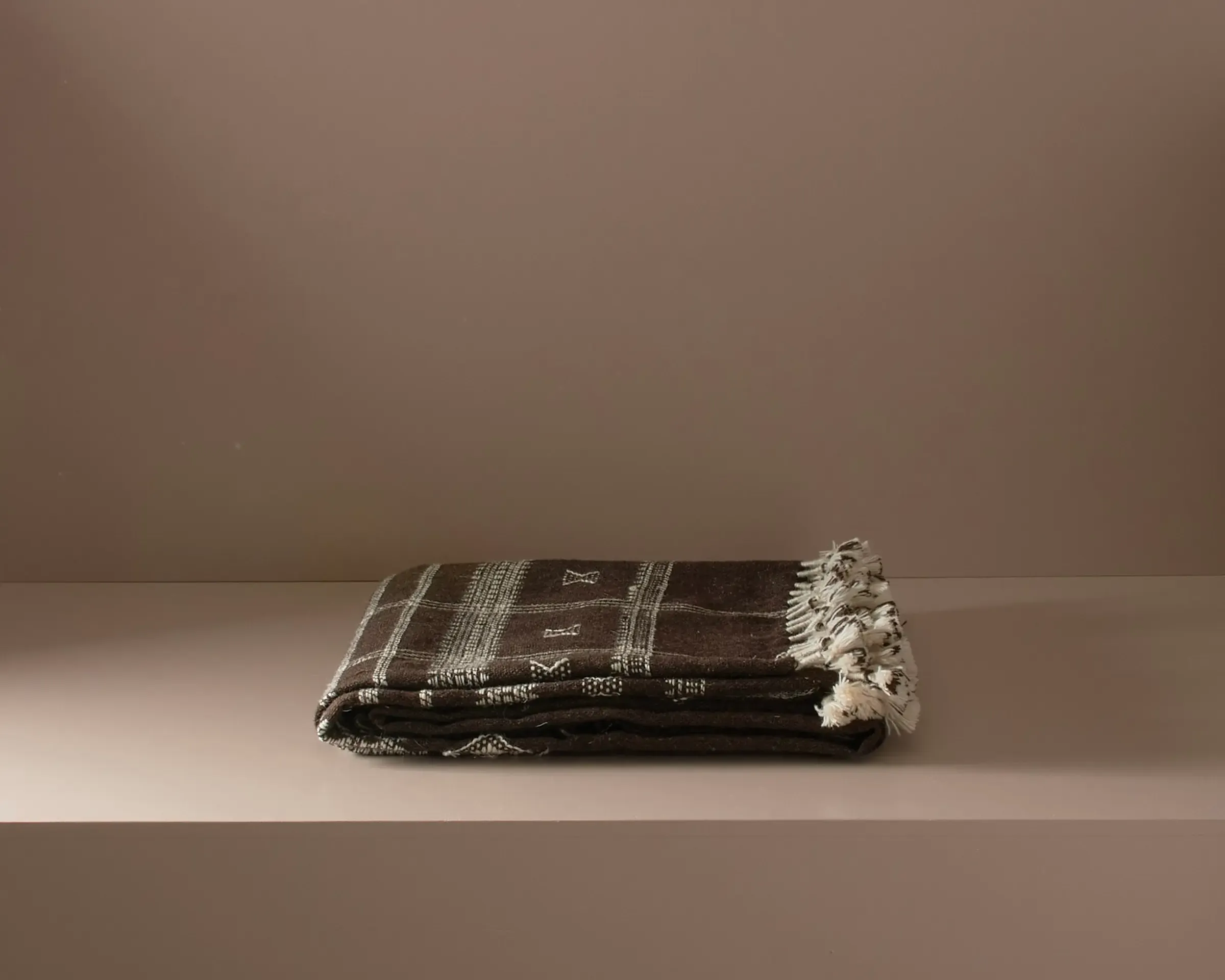 handwoven woollen throw on a neutral background