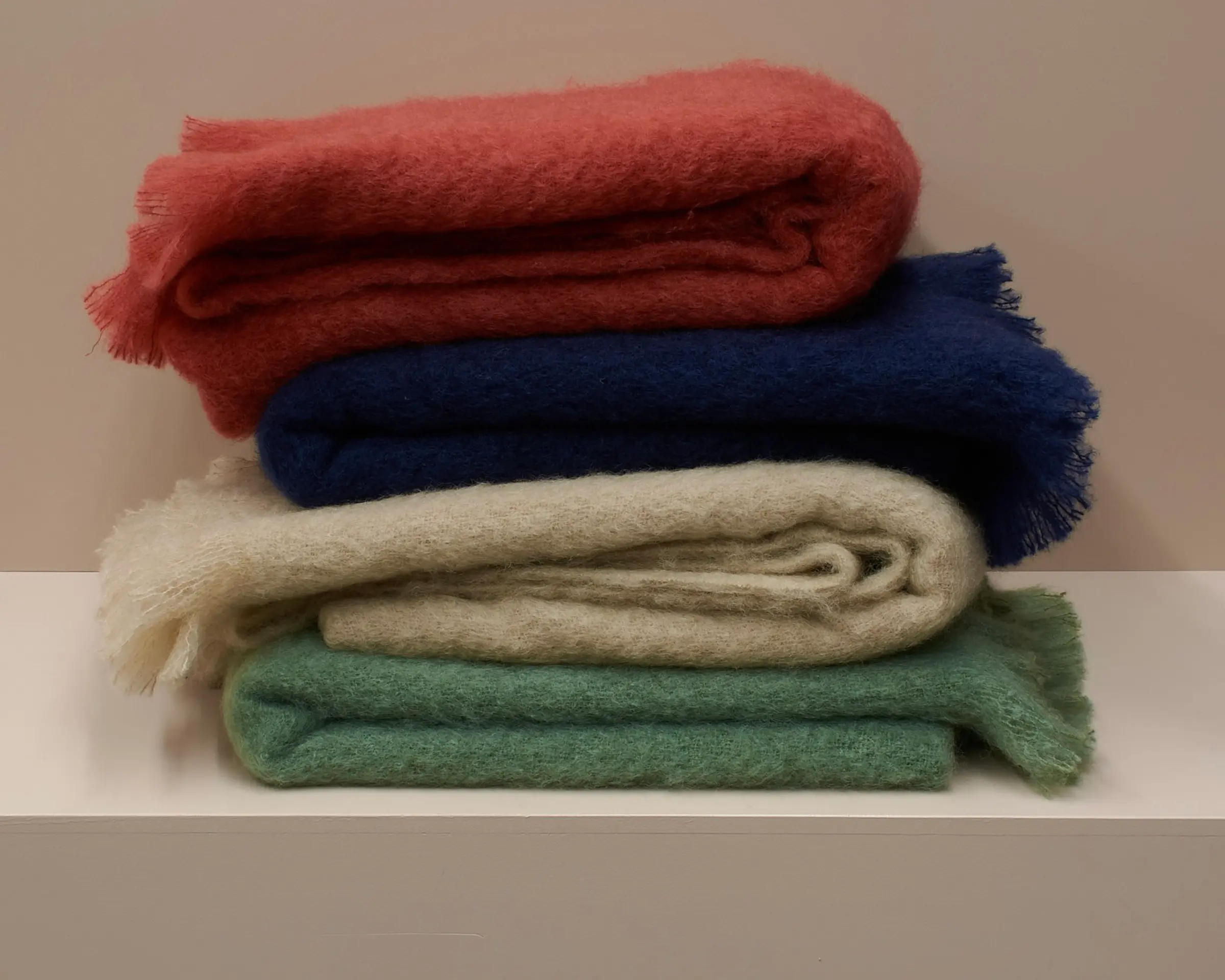 A stack of Mohair blankets on a plinth