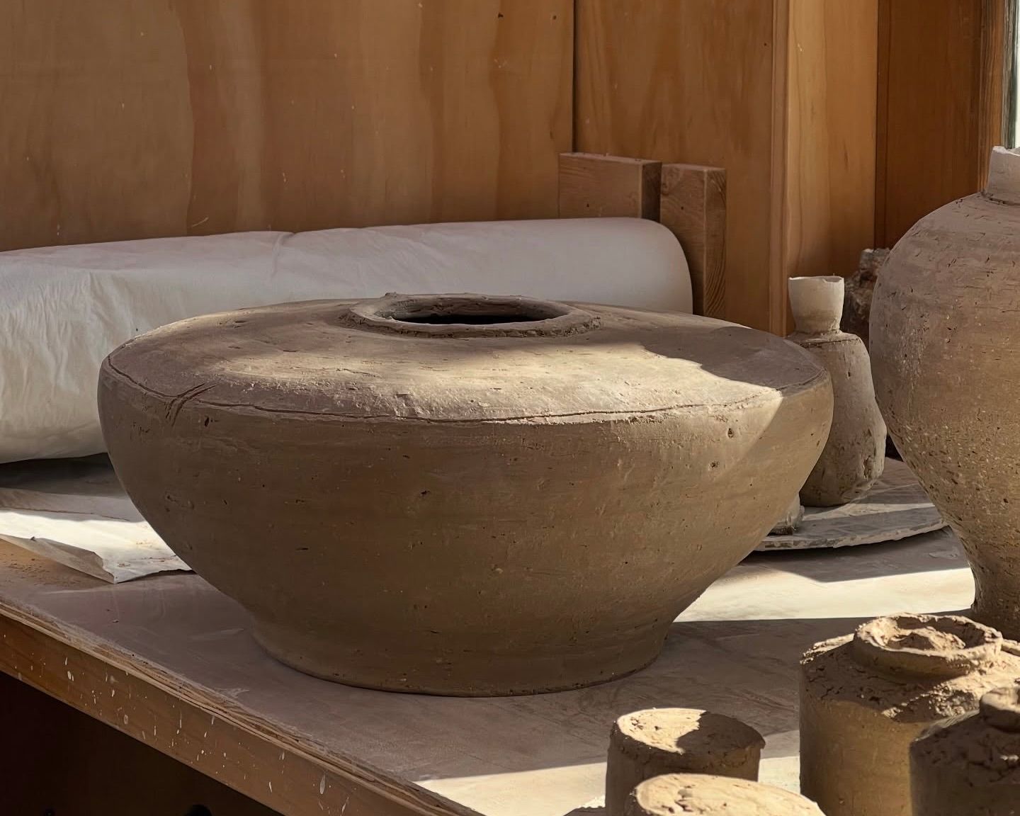 An image of working clay from Holly rose Morgans studio- a large vessel/floor pot but in clay in her studio