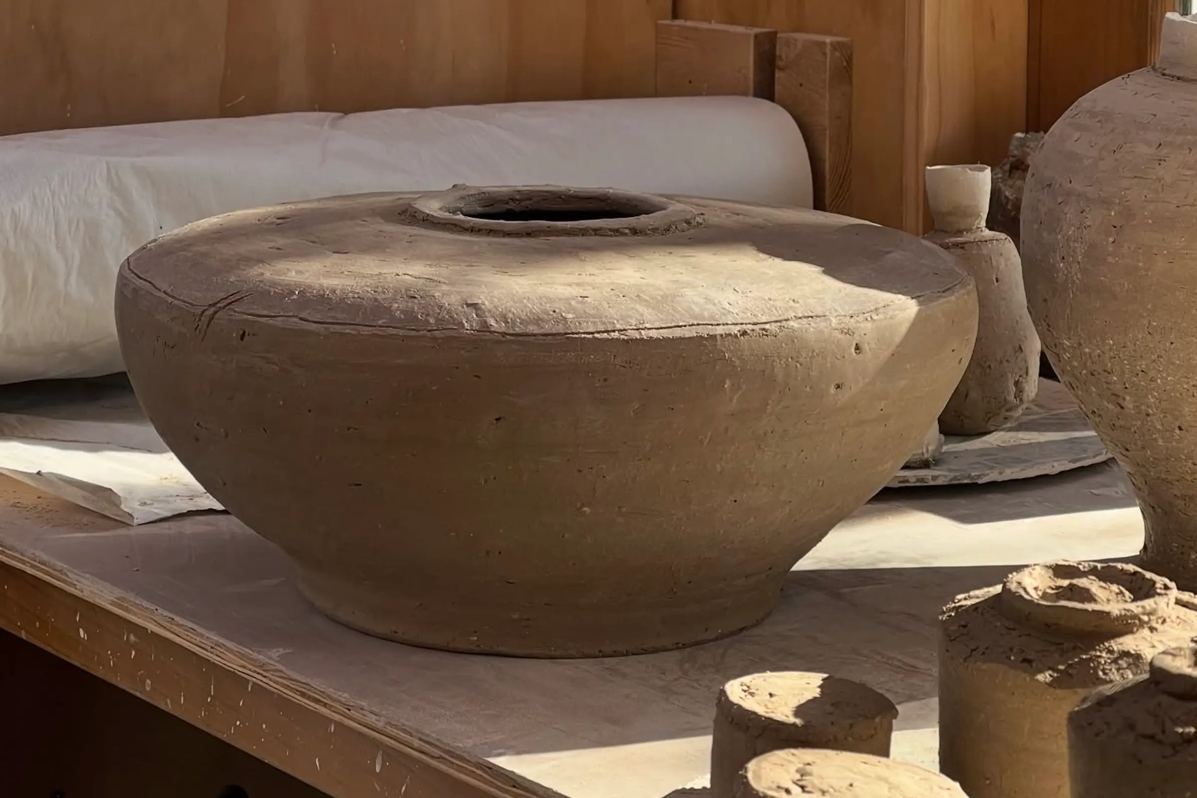 An image of working clay from Holly rose Morgans studio- a large vessel/floor pot but in clay in her studio