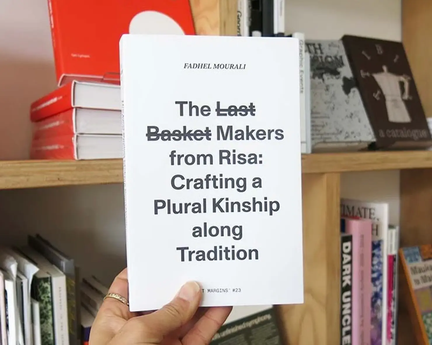 The Last Basket Makers from Risa book in hand in a bookstore setting