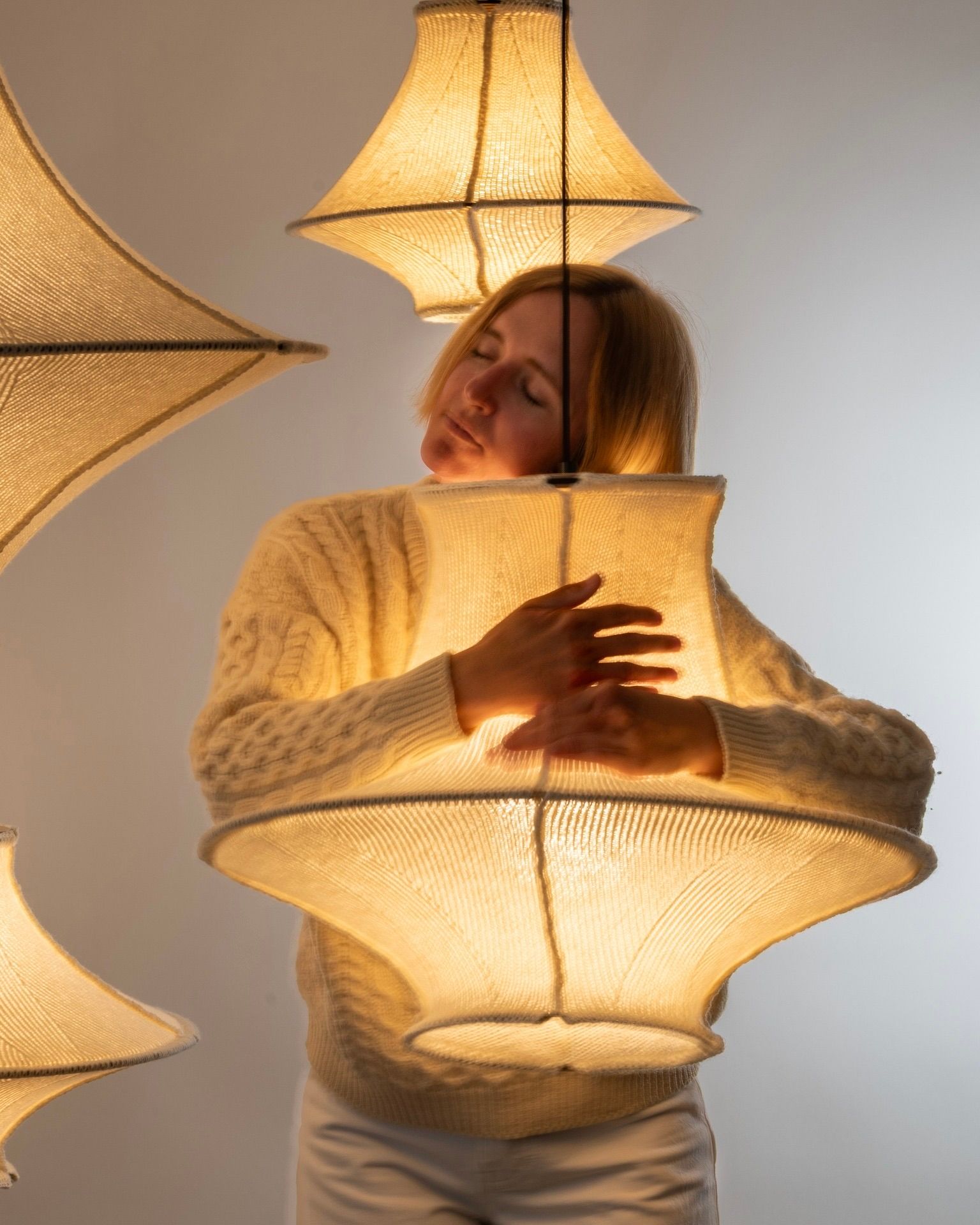 An image of Sophie Poelman the designer and owner of Lof Lighting hugging one of her Hiwa Wool light shades, made from 100% New Zealand strong wool 
