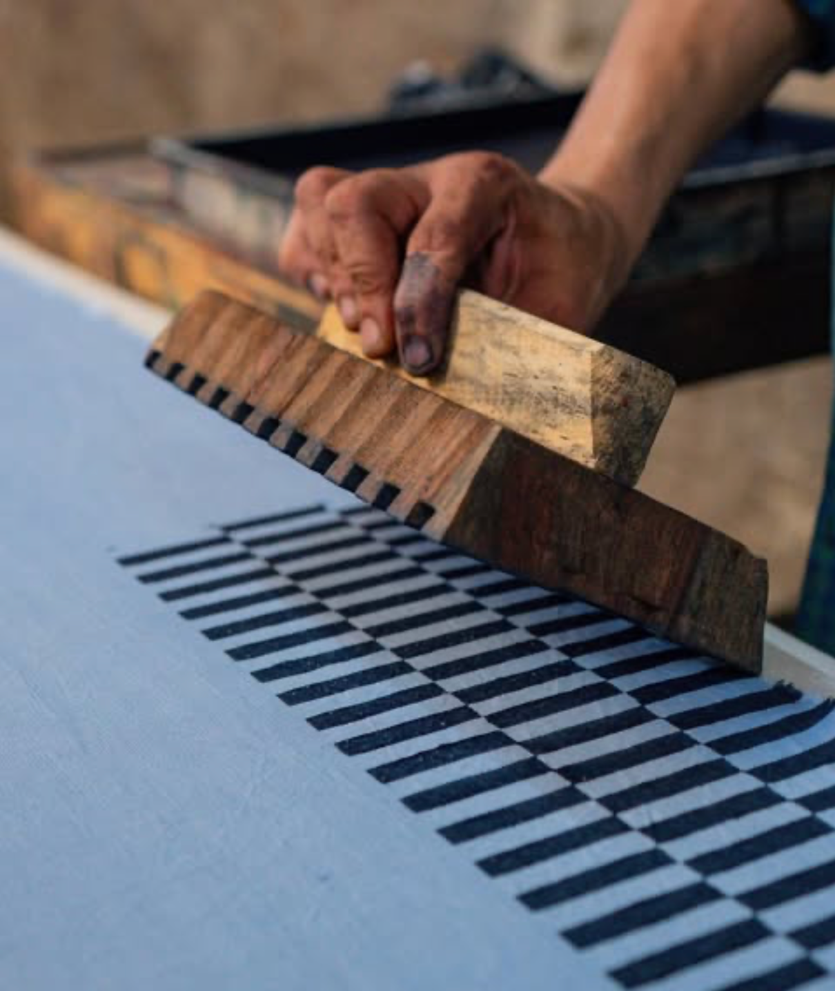 A process photo of a hand  block-printing fabric, taken in India.