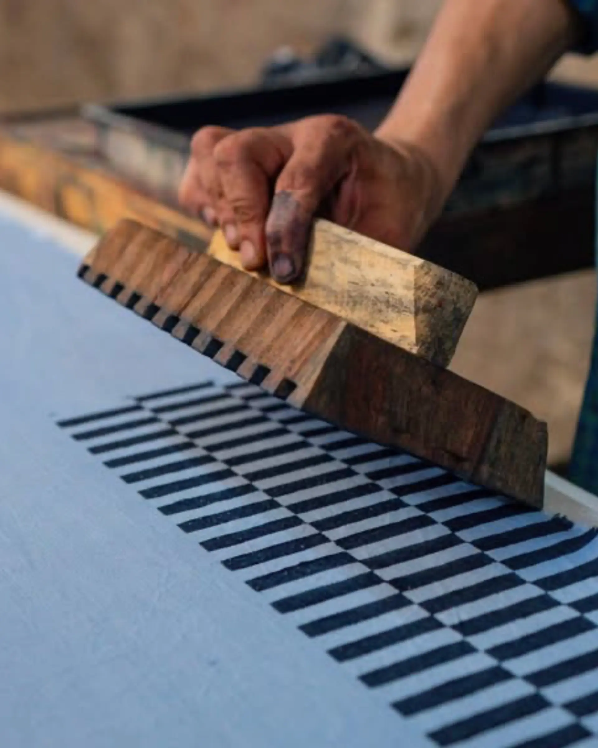 A process photo of a hand block-printing fabric, taken in India.