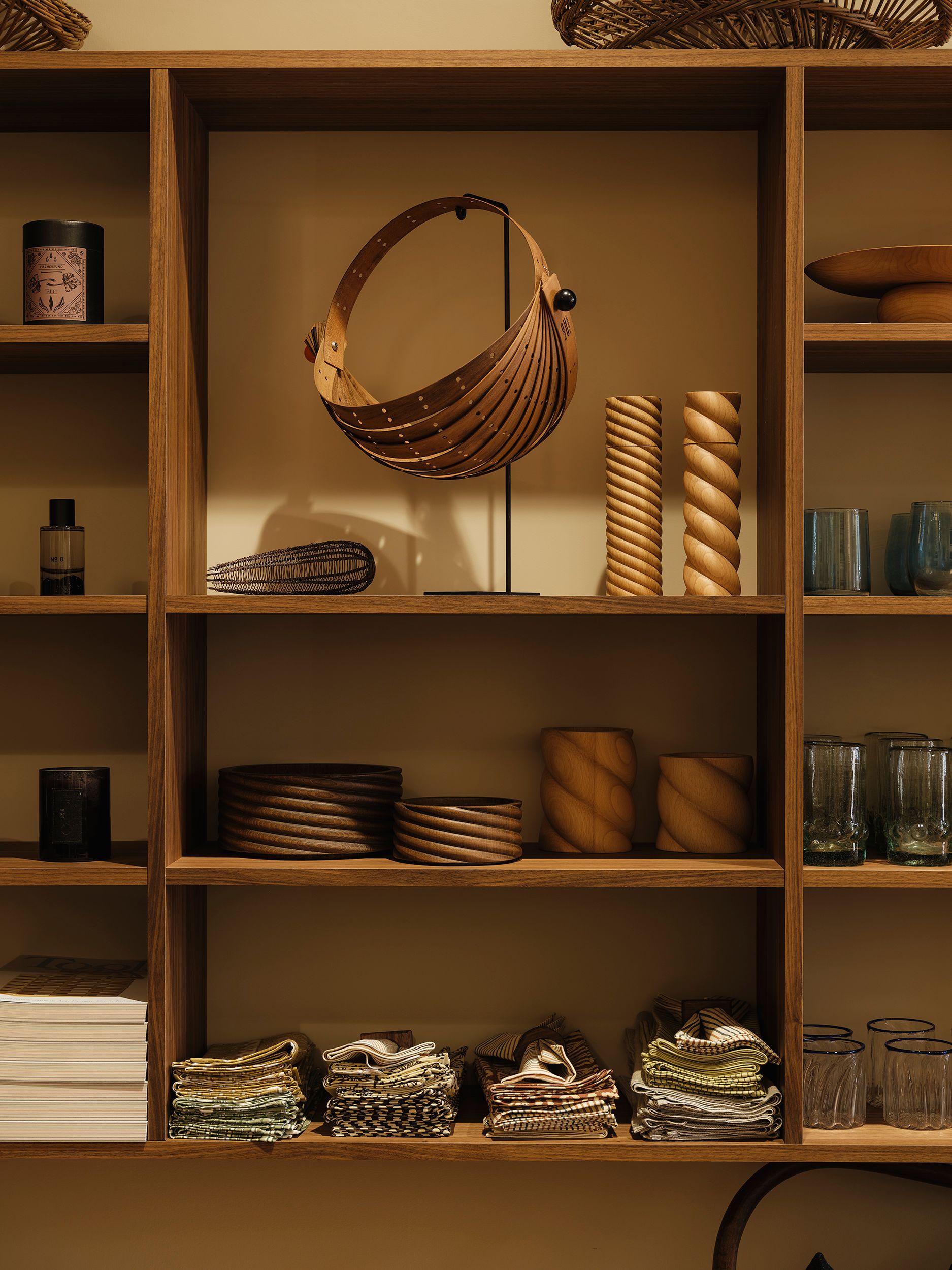 Forte Alor walnut display shelving showcasing handblown glass, baskets, woodwork and textiles inside Handcrafted Modern, Ponsonby.