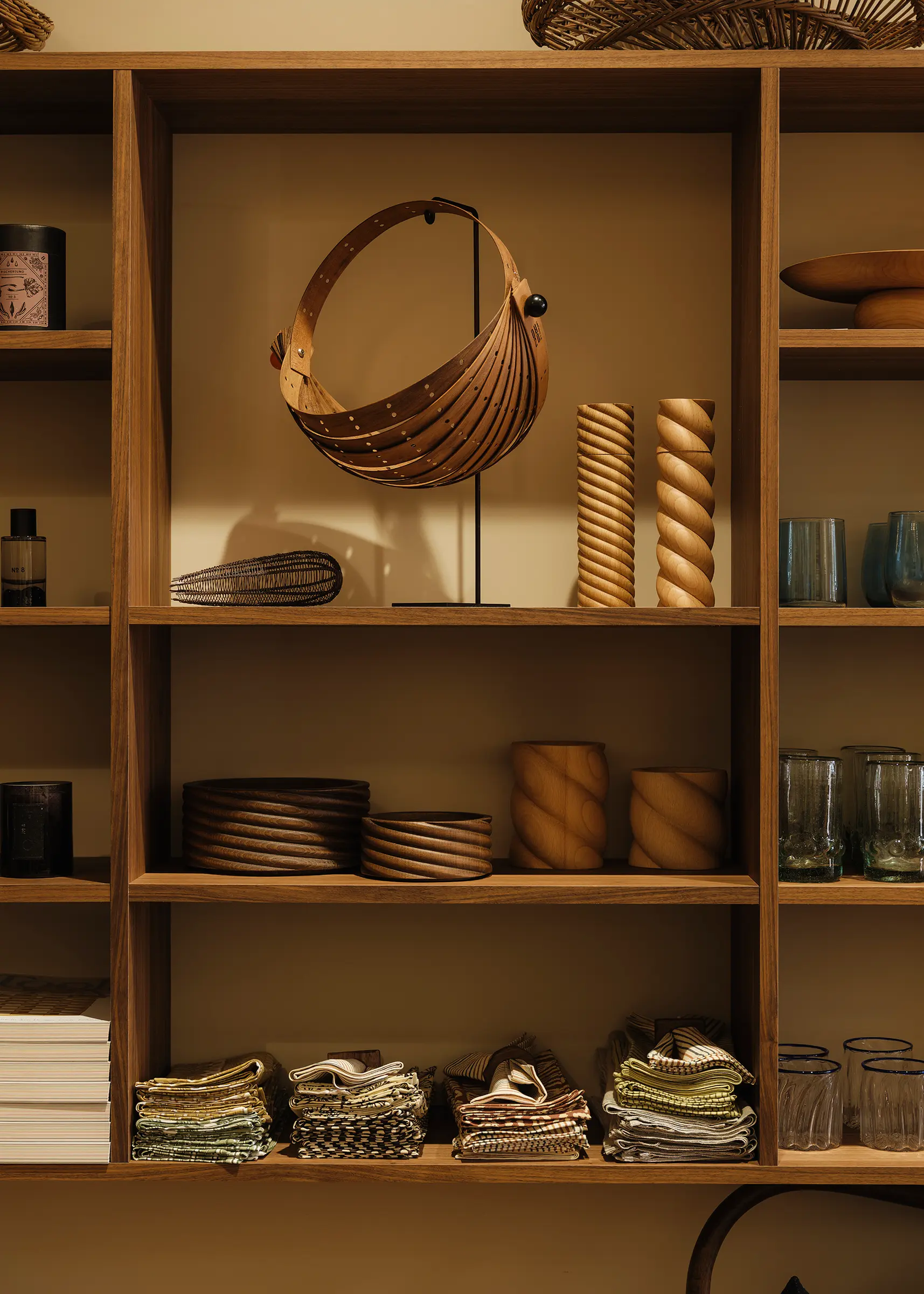 Forte Alor walnut display shelving showcasing handblown glass, baskets, woodwork and textiles inside Handcrafted Modern, Ponsonby.