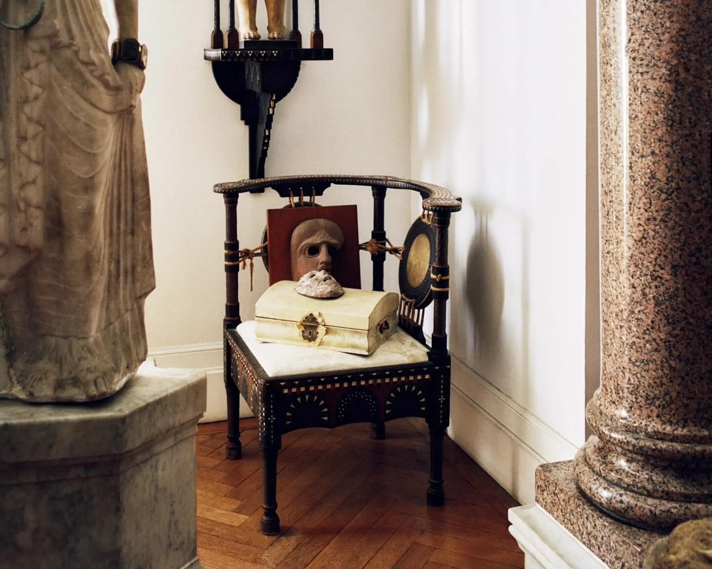 A shot from inside the Neptune papers issue 9 magazine showing an antique wooden chair with a marble sculpture next to it