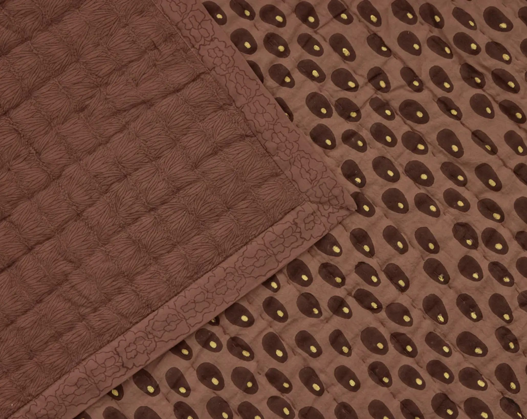 A close up of the Studio ford sphinx reversible quilt in warm brown tones
