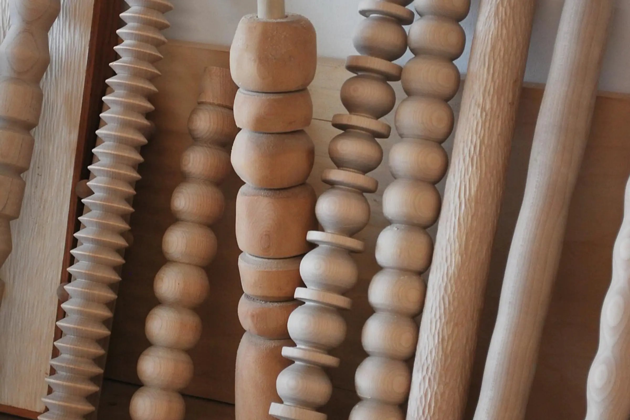 a stack of hand carved shapes to be turned into candle stick holders