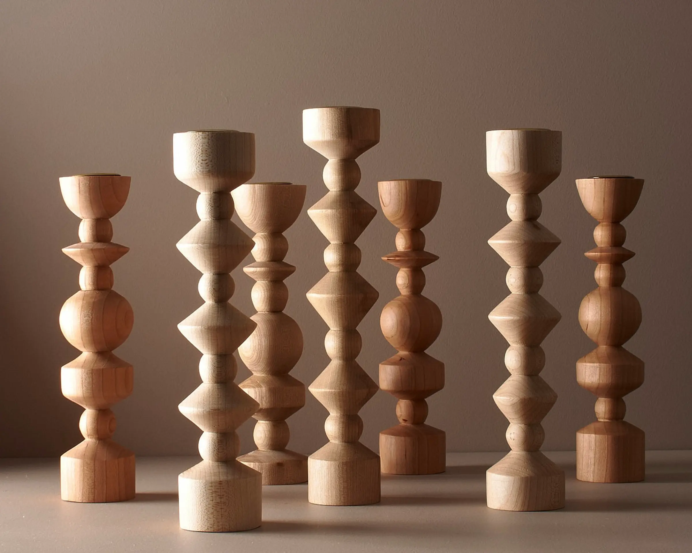 Elise mclauchlans tall and medium tapered candle holders on a brown moody background