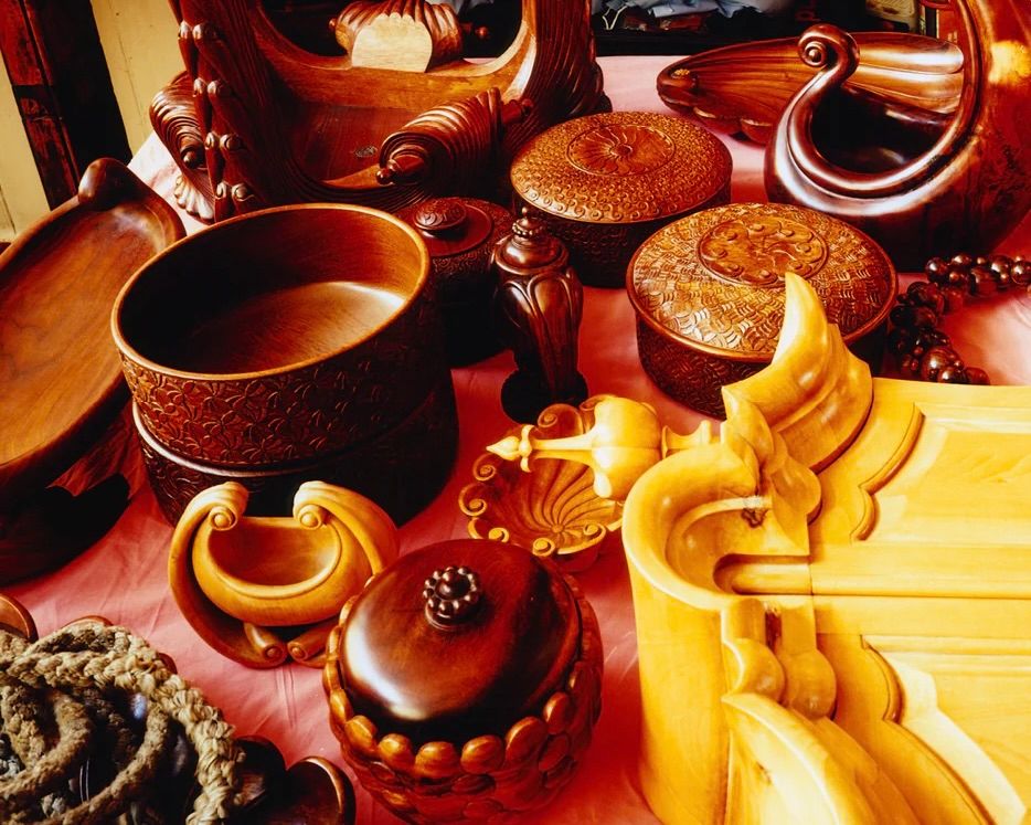 An image from inside of Scenery magazine of a collection of wooden antique bowls and vessels with hand carved patterns 