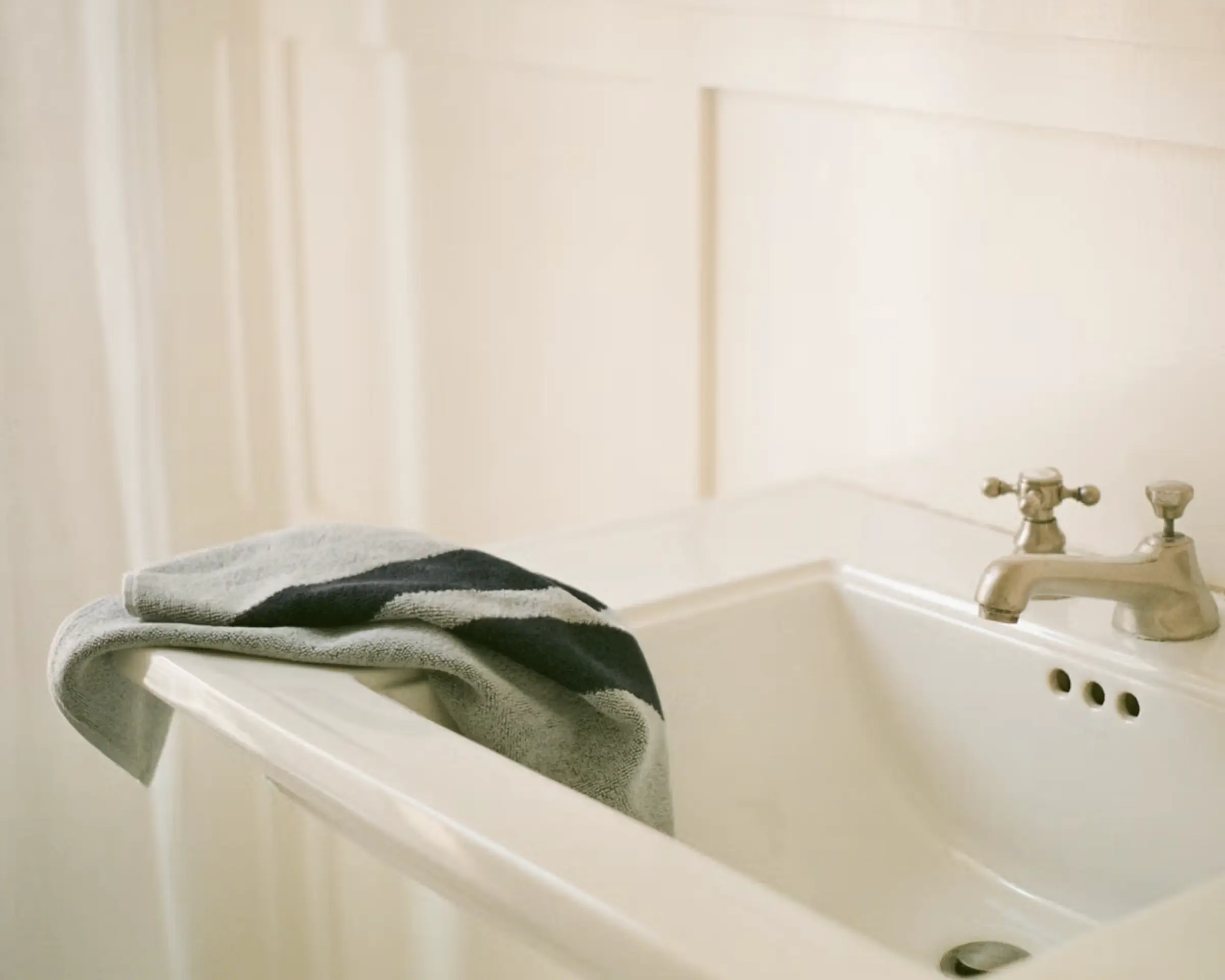 A pale blue hand towel draped over a white sink