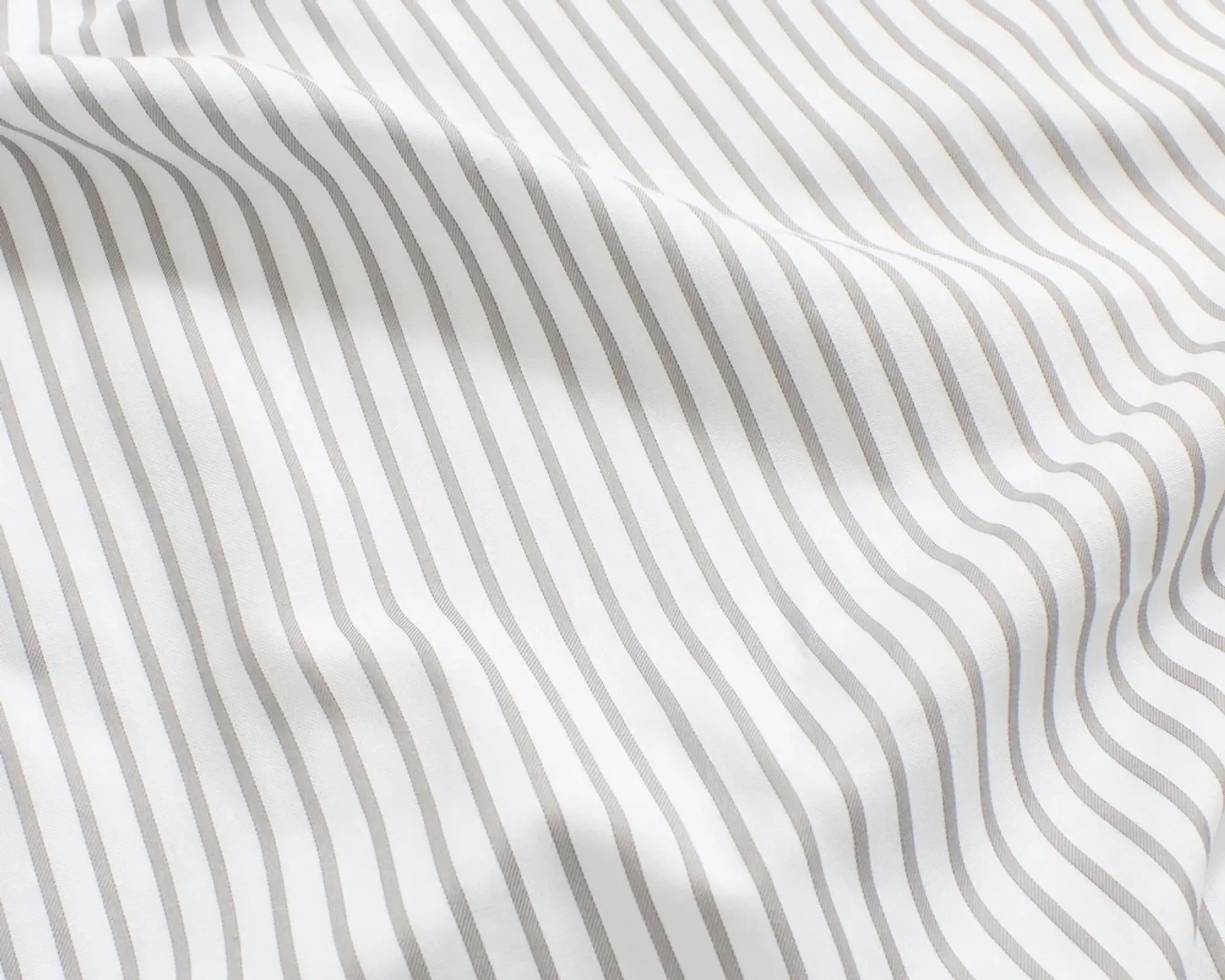 A close up detail shot of the Magniberg Wall Street Light grey stripe bedding made from 390 thread count pima cotton
