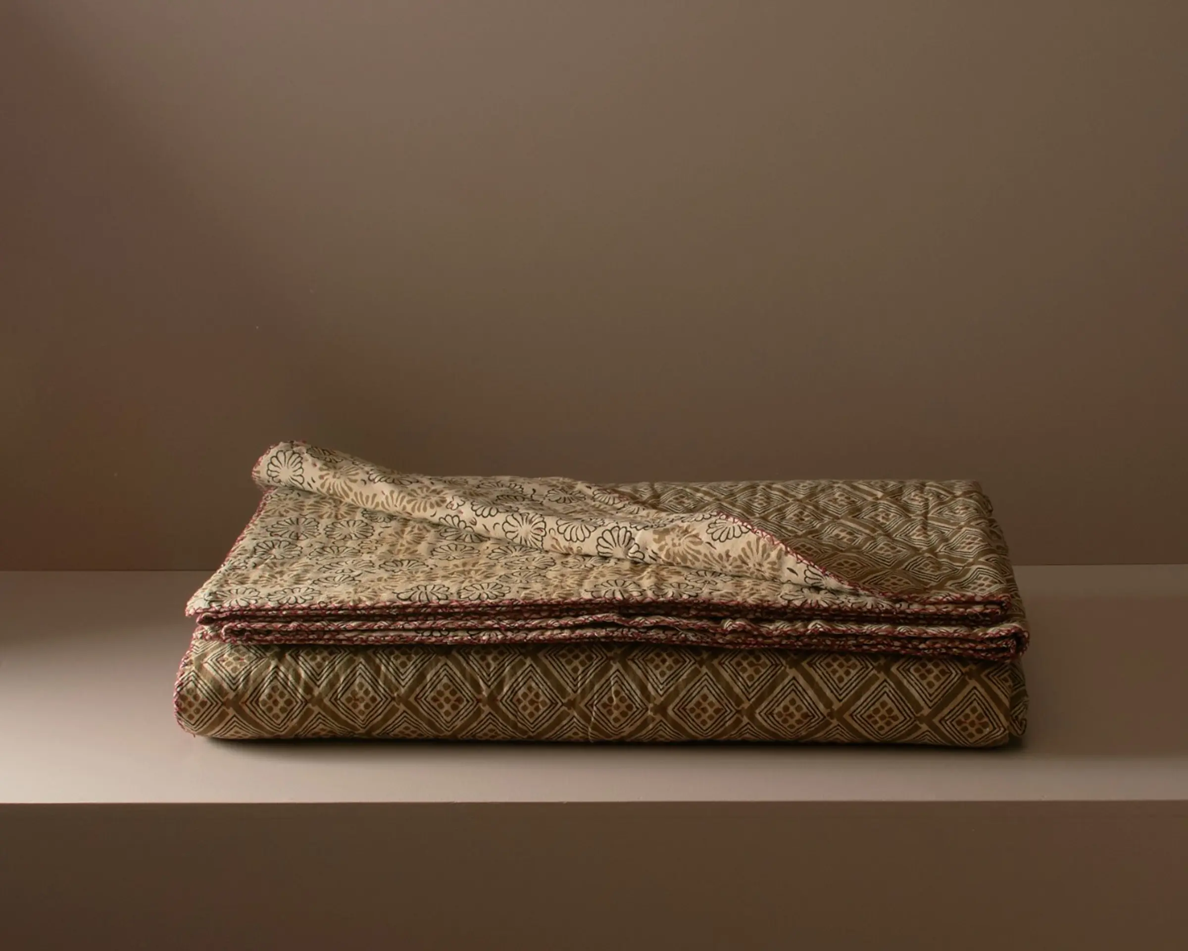 a block printed cotton quilt with diamond design