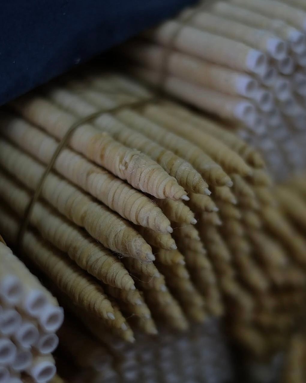 bundles of silk wrapped wash paper candles ready to be coated in wax 