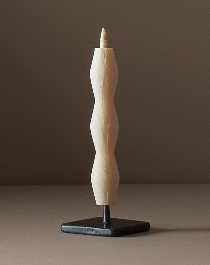 sumac wax candle on a metal stand