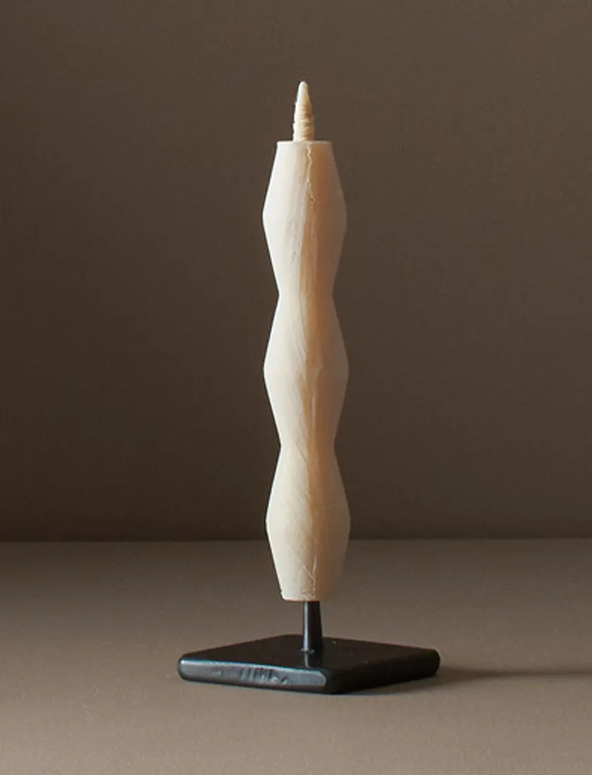 sumac wax candle on a metal stand