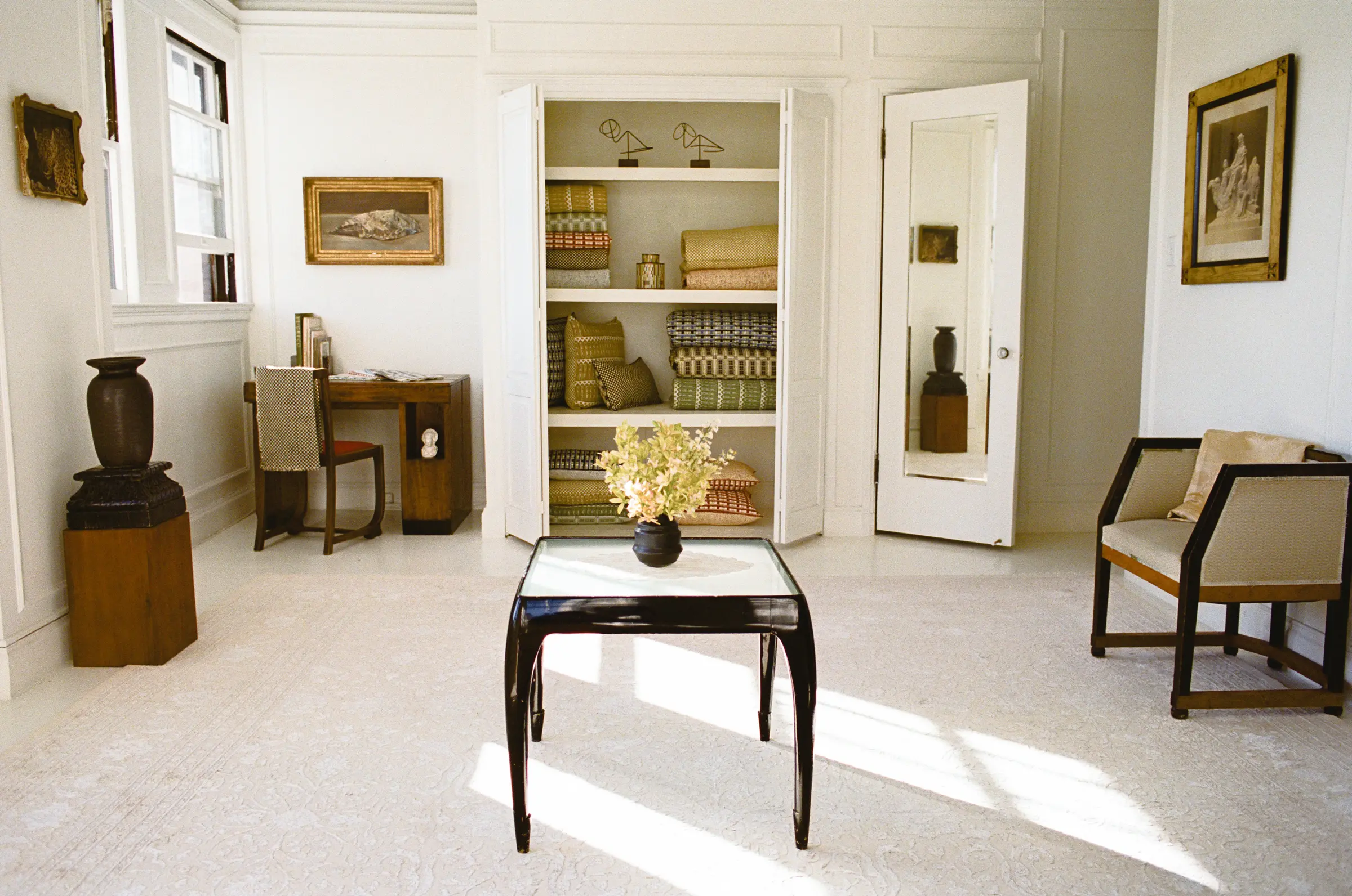 Studio Ford showroom in Los Angeles featuring antique designer furniture and shelves with folded textiles.